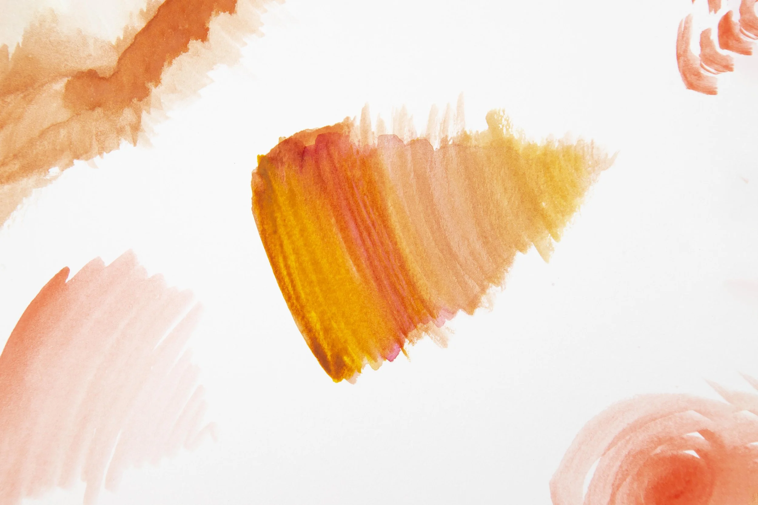 Abstract watercolor painting with orange, peach, and red brushstrokes on white paper.