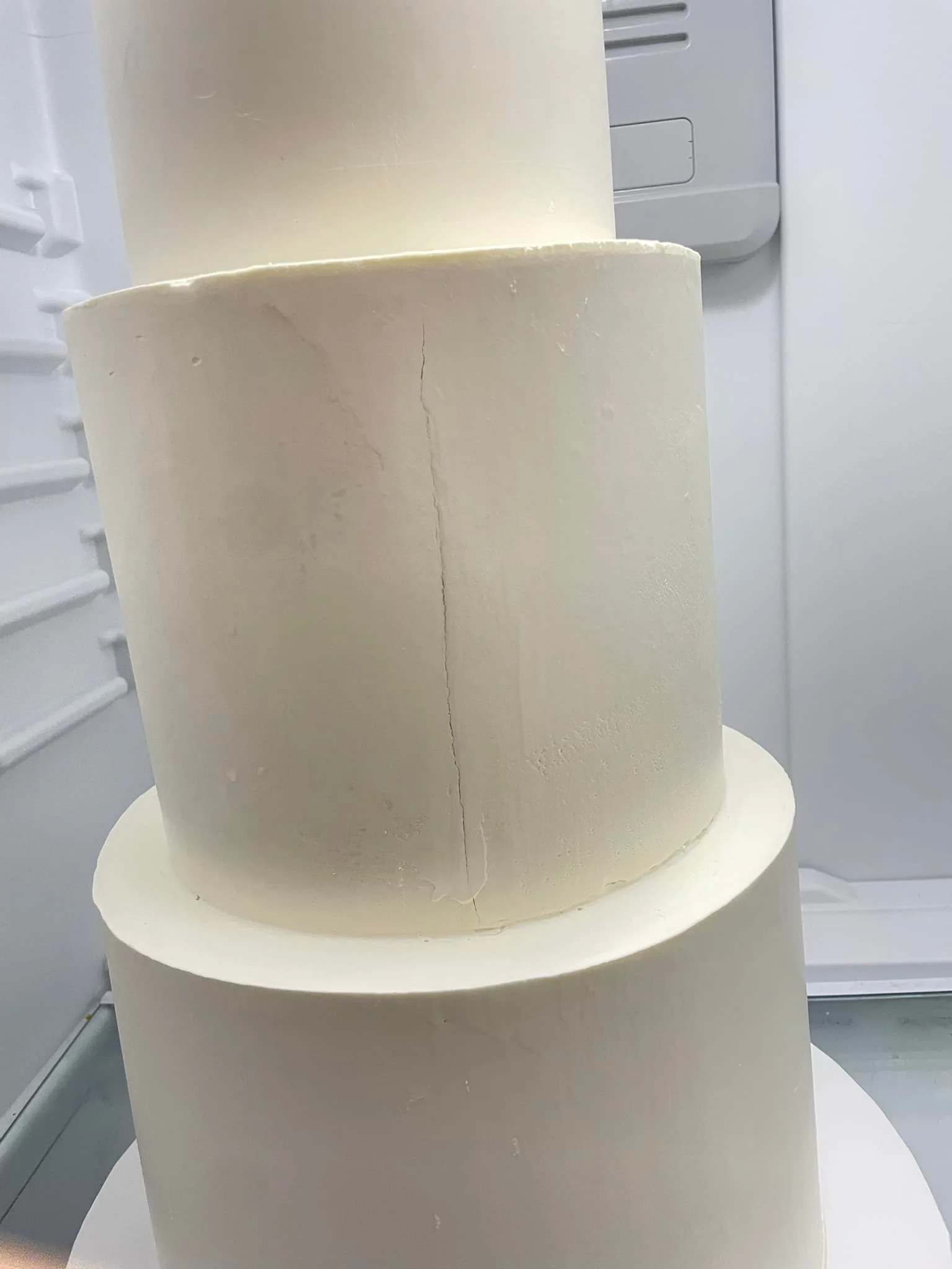 Vertical crack through white buttercream on a cake tier — photo by Terri Ramsay