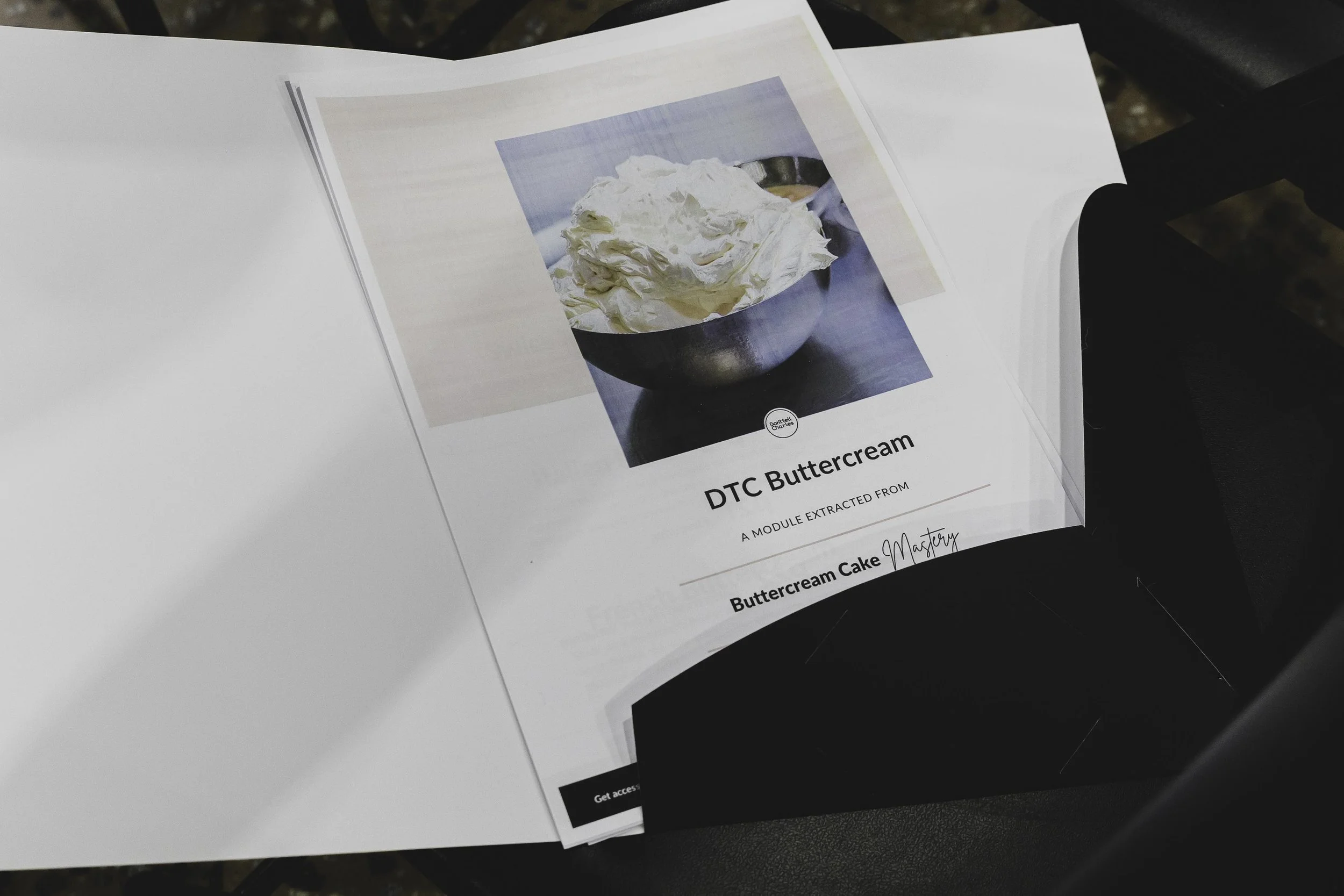 Printed page showing a photo of whipped cream in a bowl with text describing DTC Buttercream and Buttercream Cake from Buttercream Mastery.