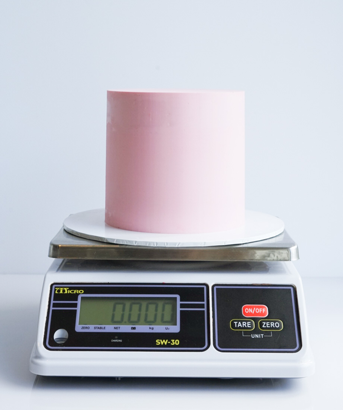 Cake filled and covered with buttercream on a kitchen scale to record Weight C