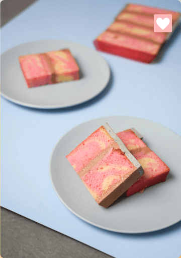 Marbled soap bars on white plates with a pink heart icon in the top right corner.