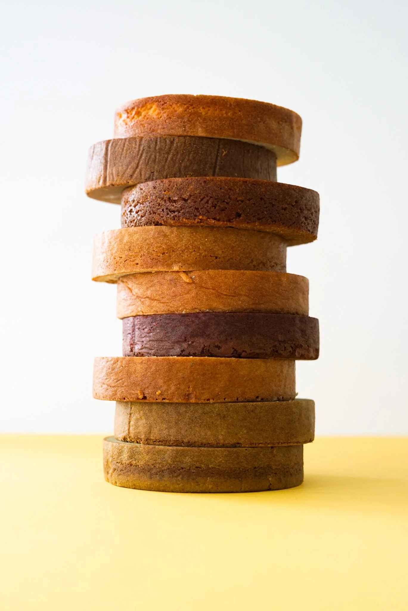 A tall stack of baked cake layers showing the foundations of a sturdy layer cake