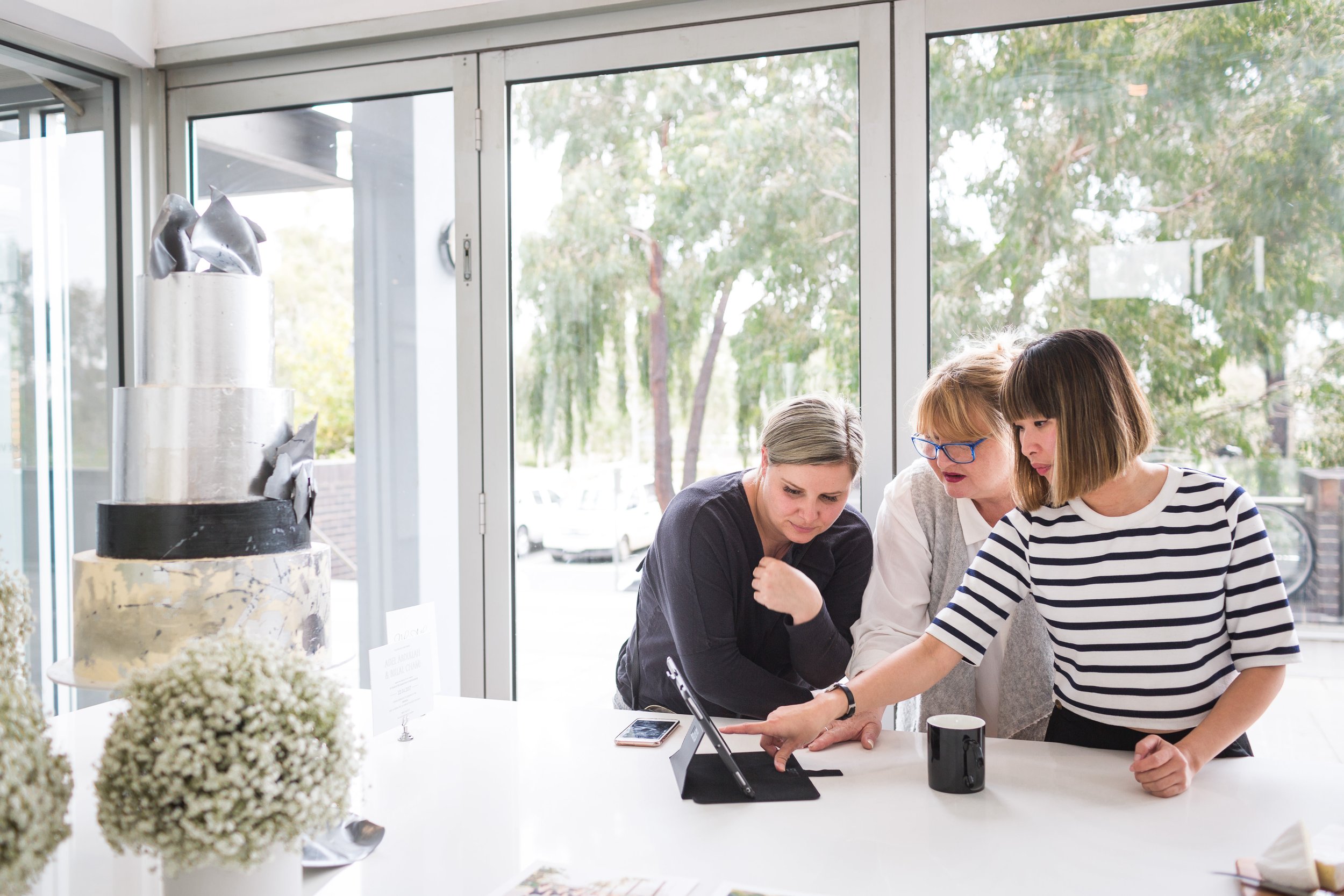 Thao Armstrong discussing cake requirements with clients at a cake consultation