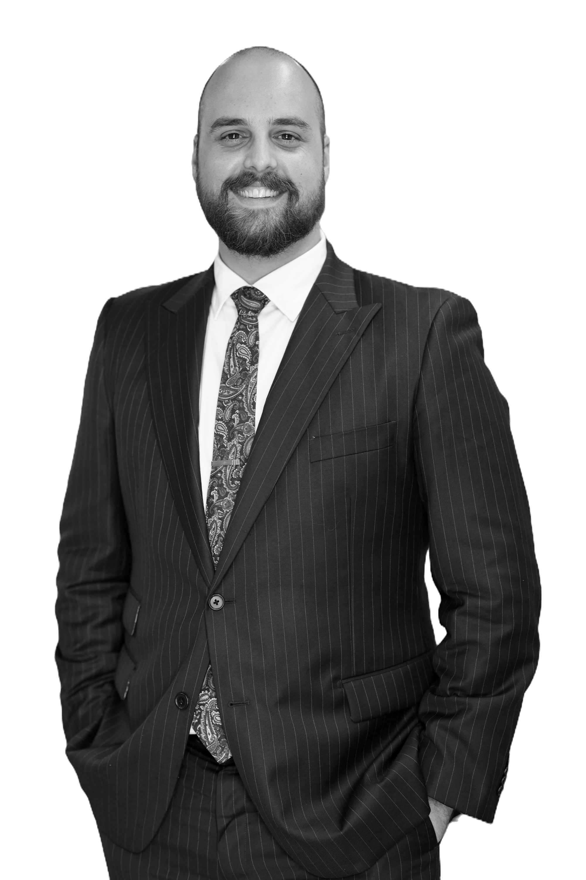 A man in a business suit smiling, with a beard, wearing a striped suit and paisley tie.