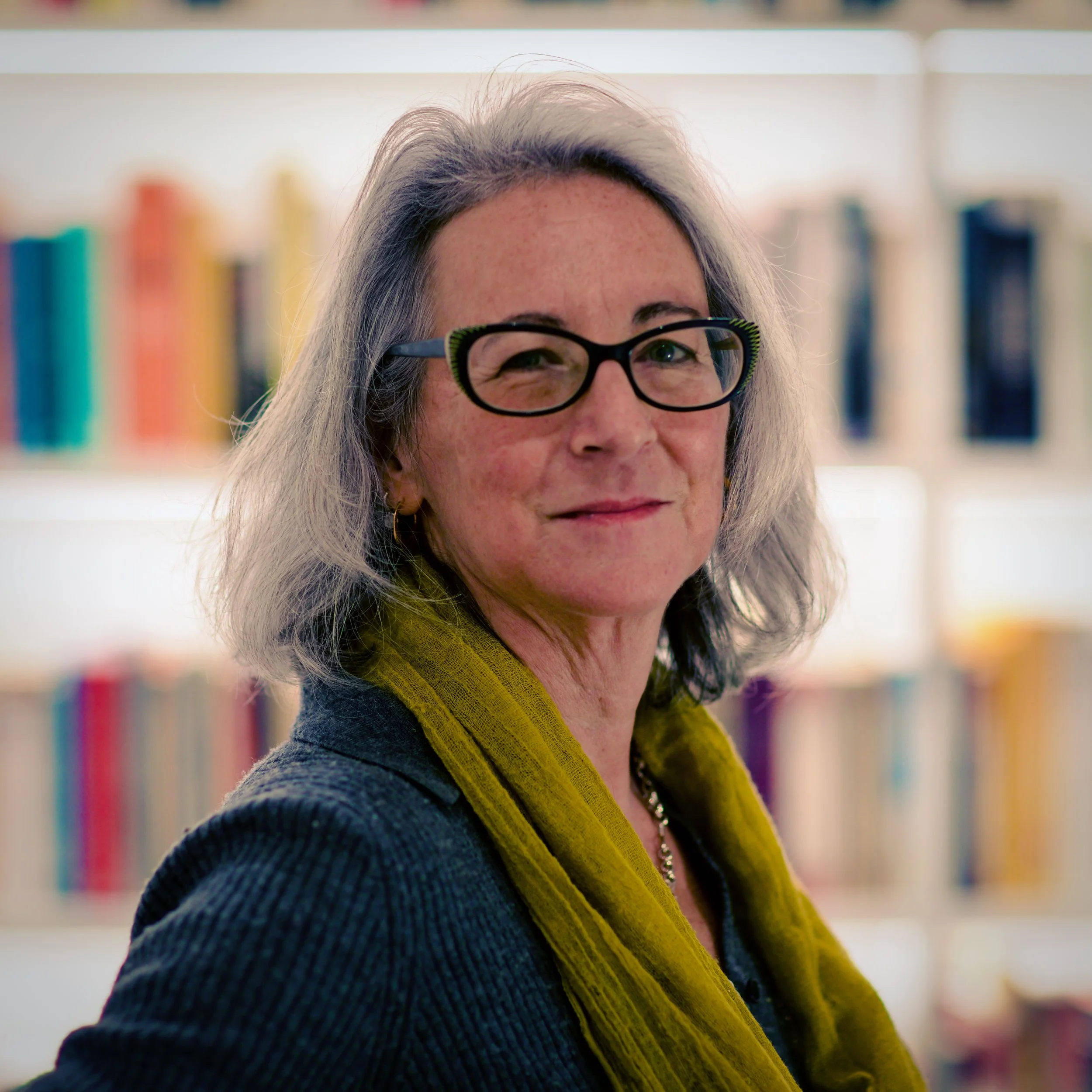 Dr Sarah Wynick standing in front of a bookshelf.