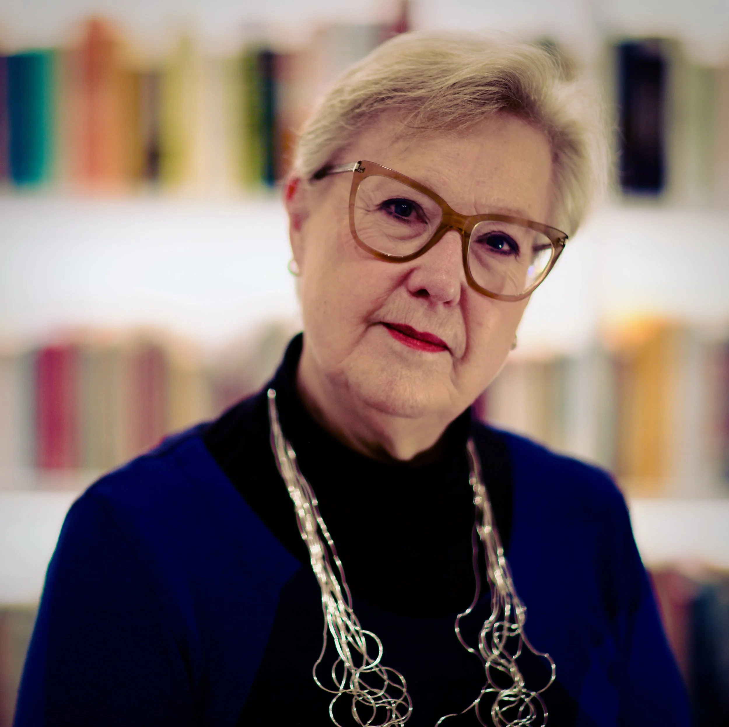 Jane Wynn Owen standing in front of a bookshelf.