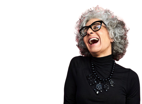 An older woman with curly grey hair, wearing glasses and a black turtleneck, laughing and looking to the side.