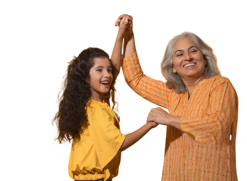 A young girl and an older woman smiling and holding hands, celebrating or dancing together. They are both wearing shades of yellow.