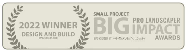 A gray certificate plaque with text recognizing a 2022 winner in a design and build competition, sponsored by Provender. It mentions a small project with big impact, under $35,000, and includes awards and project details.