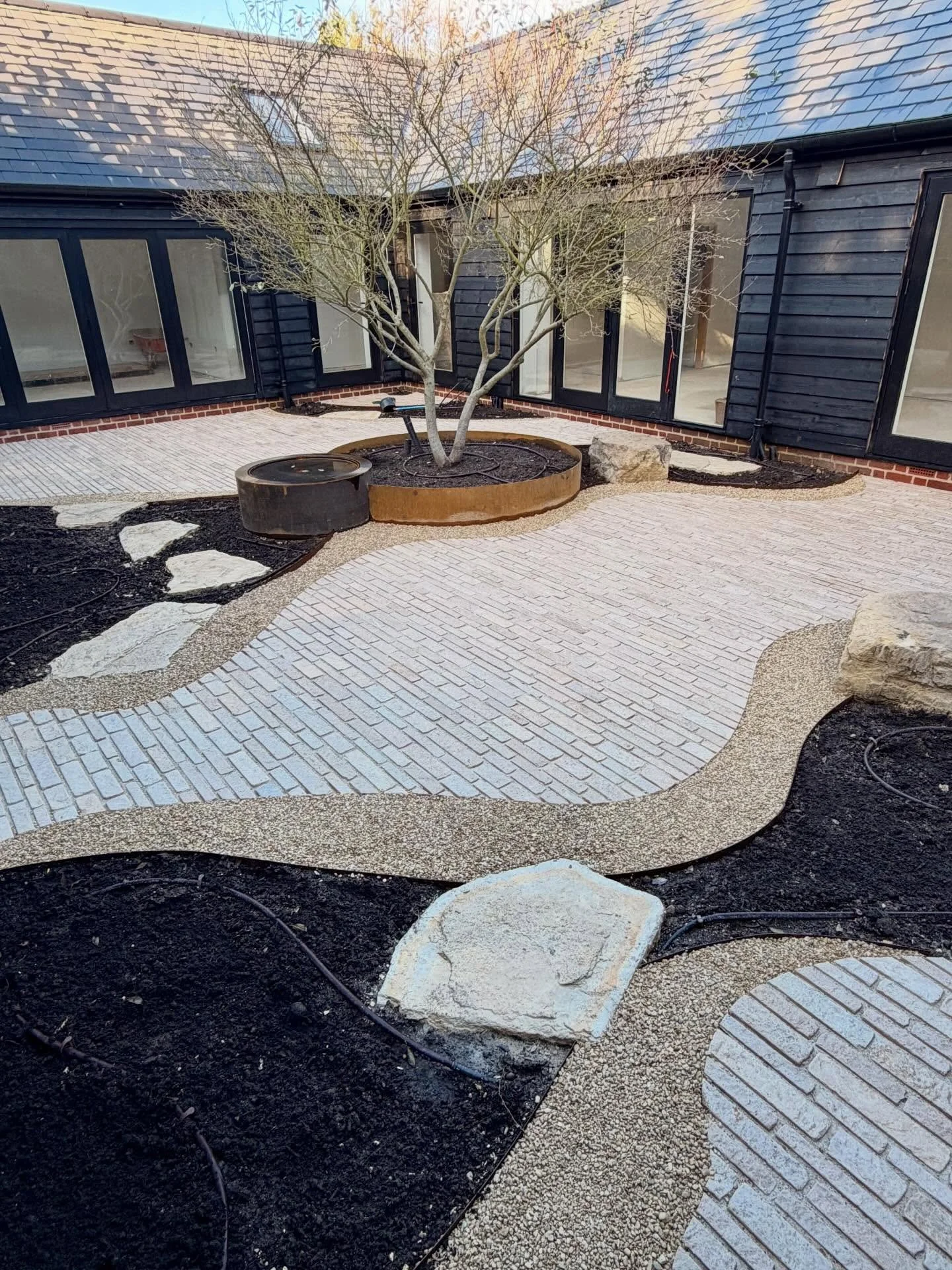 Surrey courtyard we were working on end of 2025 with a wonderful mix of limestone pitchers, corten steel planter, edging and Cotswolds pebbles. Expertly built by @andreioprea499, Mihail and Nicolas. Planting has been delayed till March but excited th