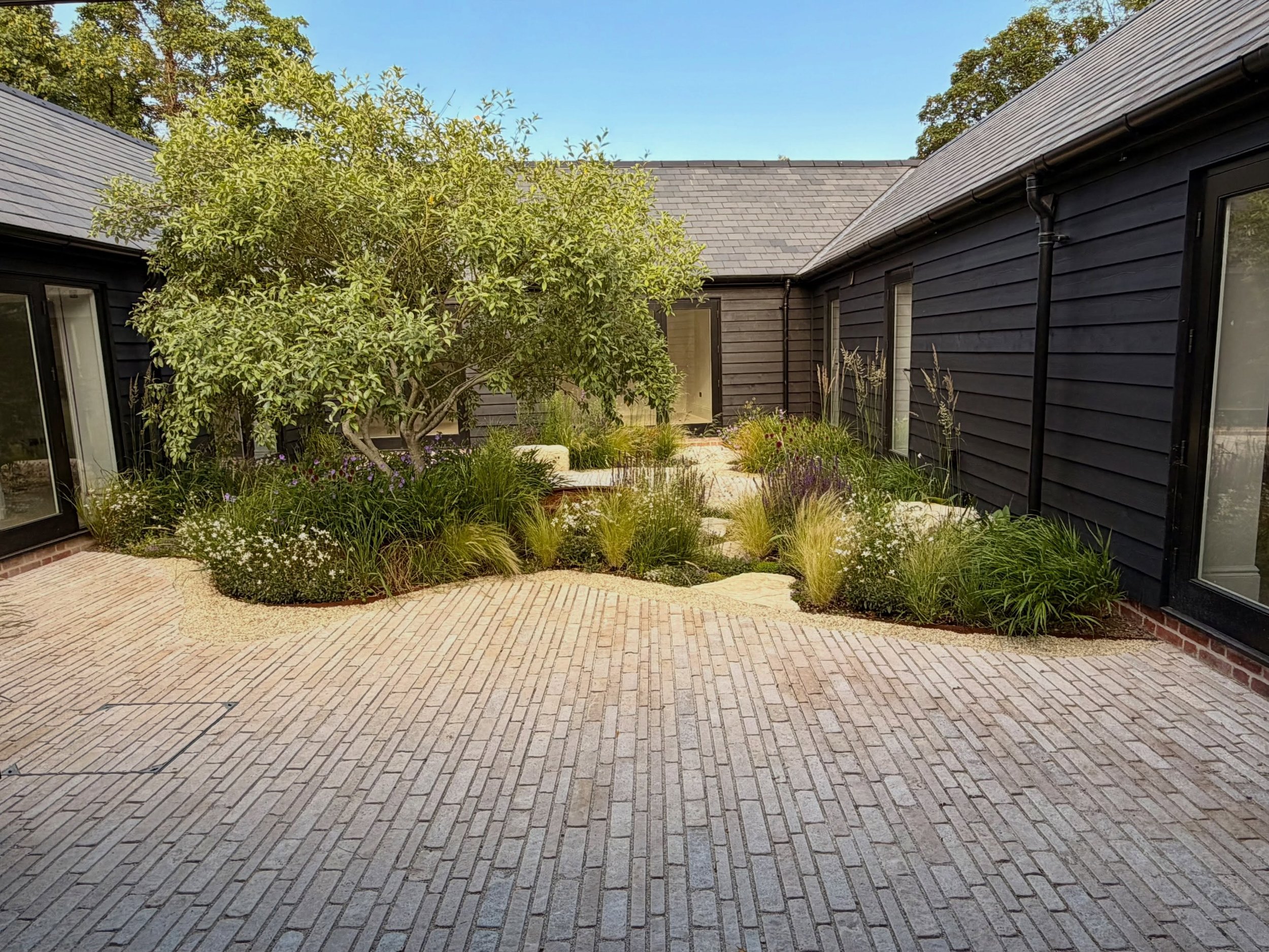 A tranquil courtyard garden sitting in the centre of a redeveloped stable block. A simple palette of materials and planting that provides movement, texture and calm. 

Design&amp;Build: @tomhowardgardens @andreioprea499 
Stone&amp;Gravel: @allgreengb