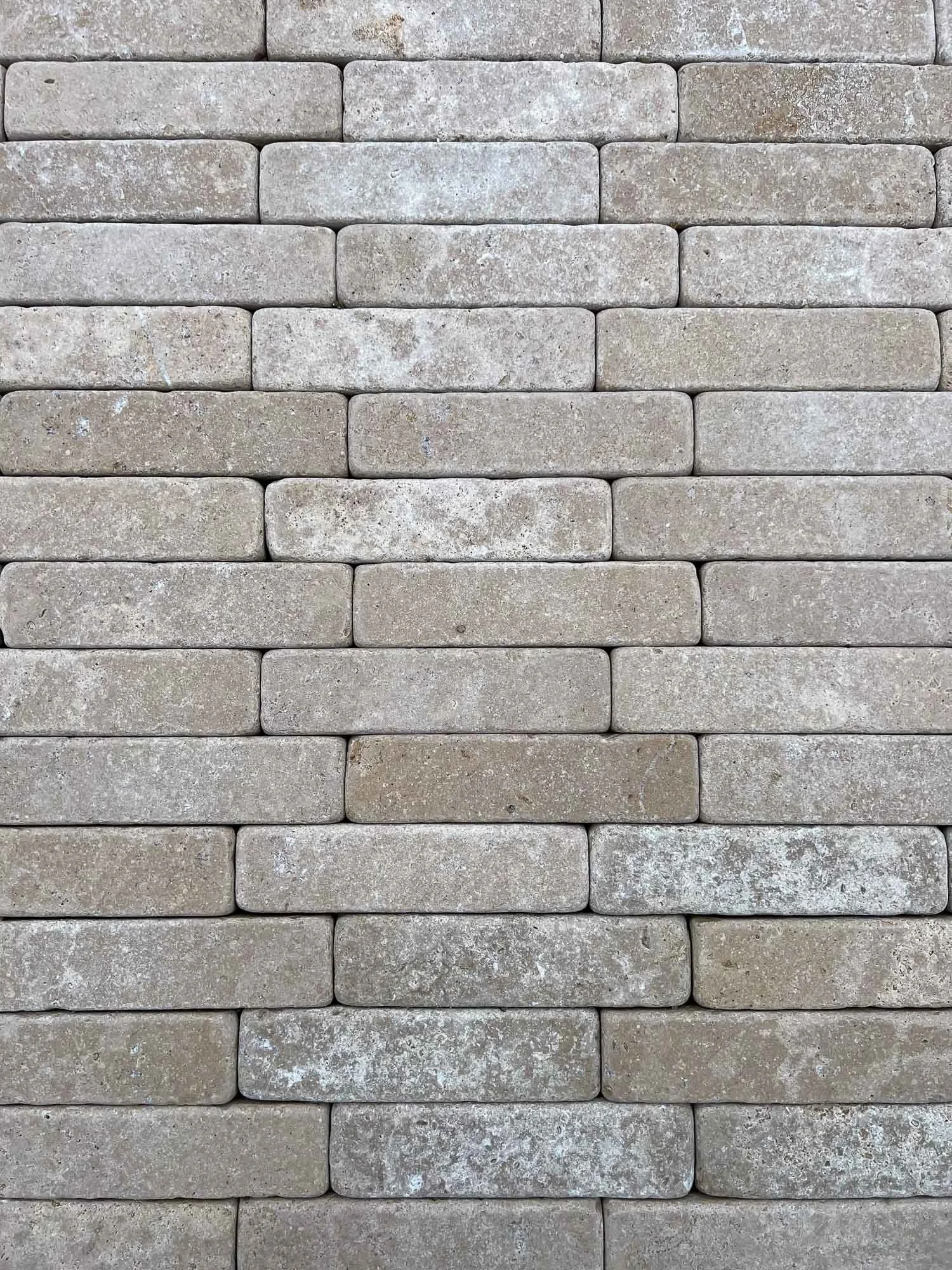 Close-up view of a brick wall with rectangular stones laid in a horizontal pattern.