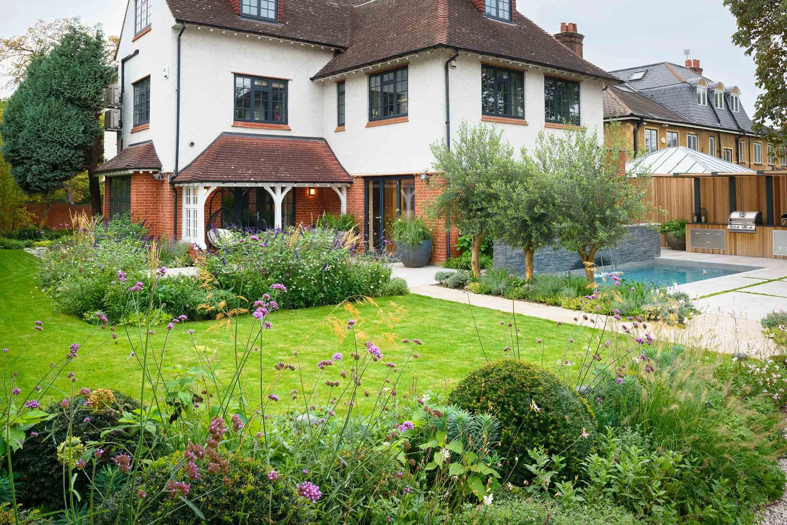 Rear view of a family home with expansive lawn and informal planting