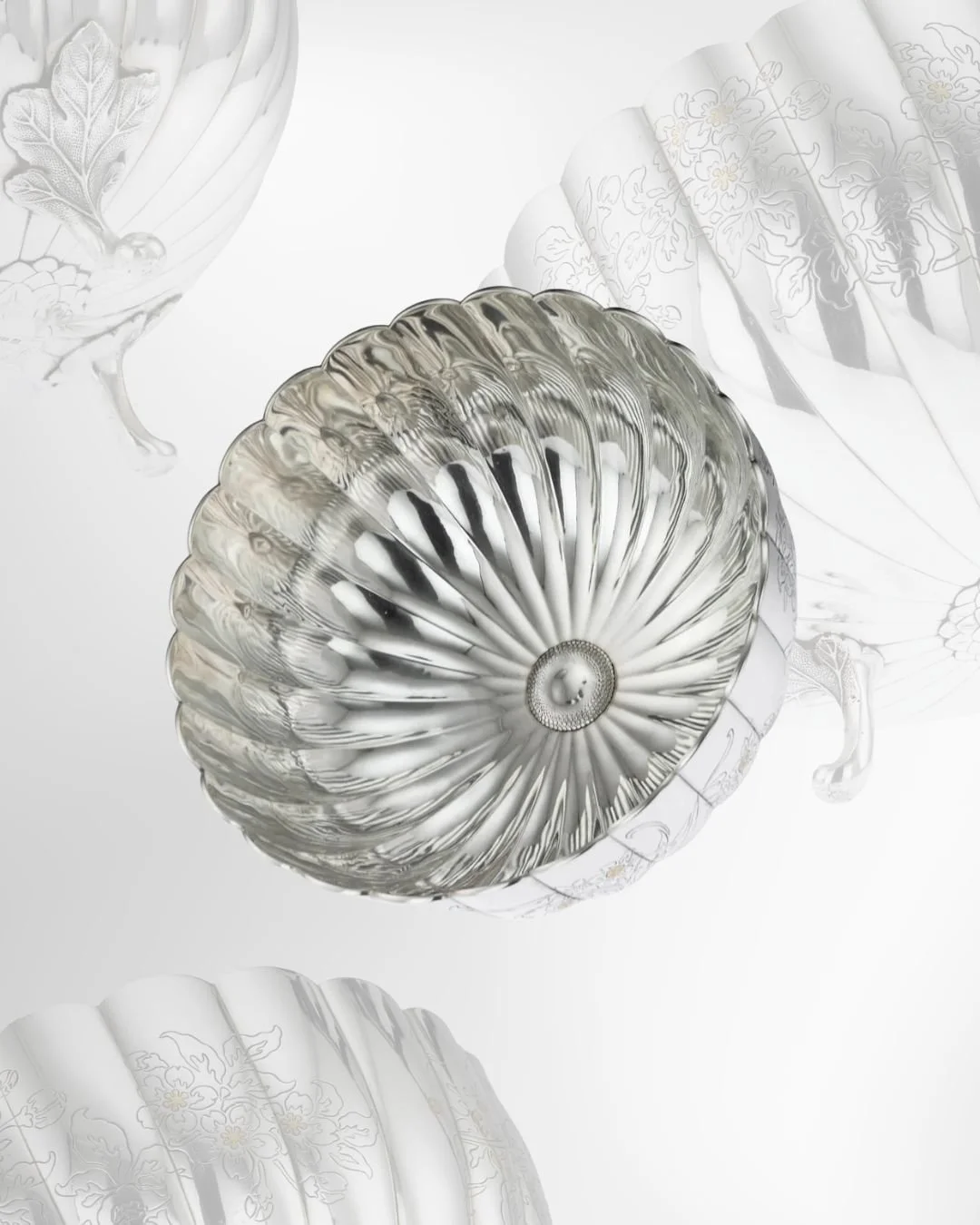 A decorative glass ceiling light fixture with a floral pattern. It is silver and surrounded by translucent fabric or glass with floral embroidery.