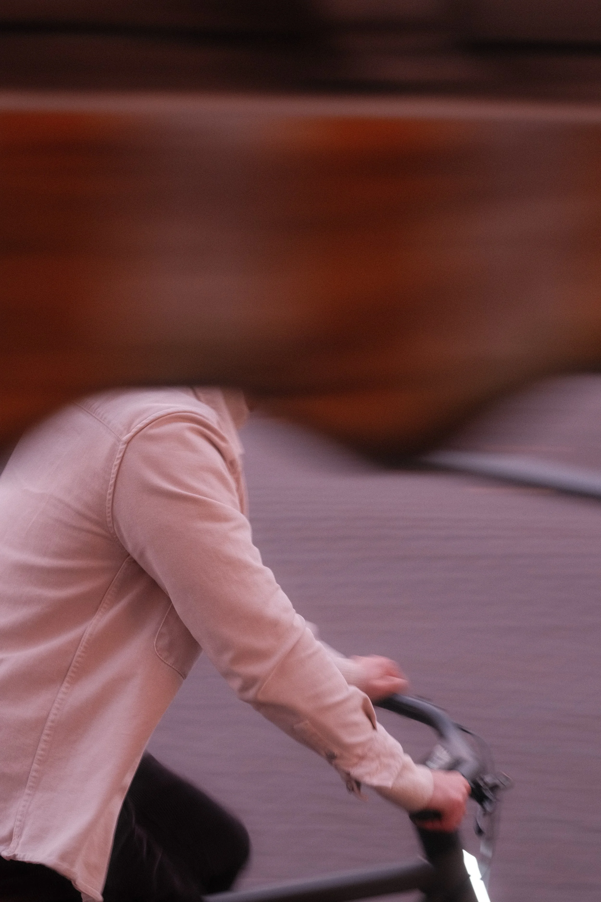Person riding a bicycle on a street, captured in motion with blurred surroundings.