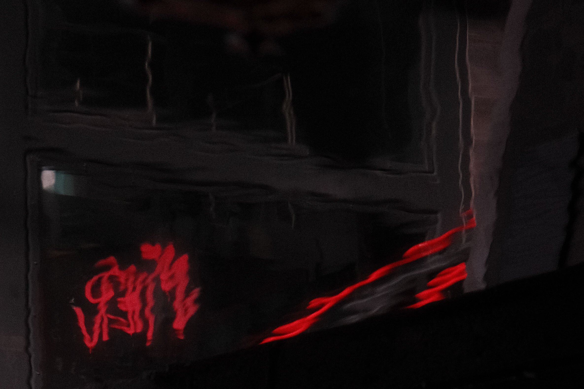 Close-up of a black object with red neon-like text that appears to say "VAPE" on a dark background.