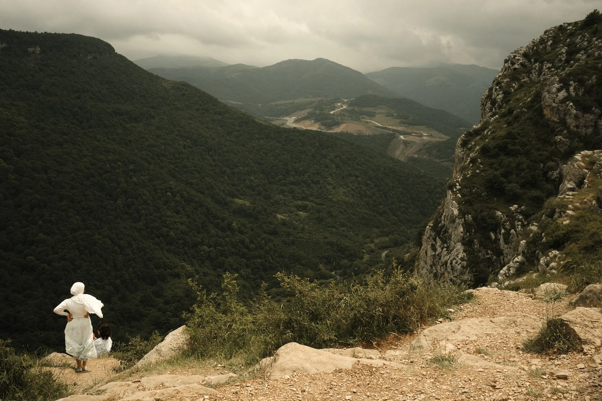 A woman looks out from the clifftop at Shusha. The phrase "next year in Shusha" is one known by many Azerbaijanis - a symbol of hope and perseverance that one day they will return to Karabakh. Perched above the valley, Shusha has long been seen as th