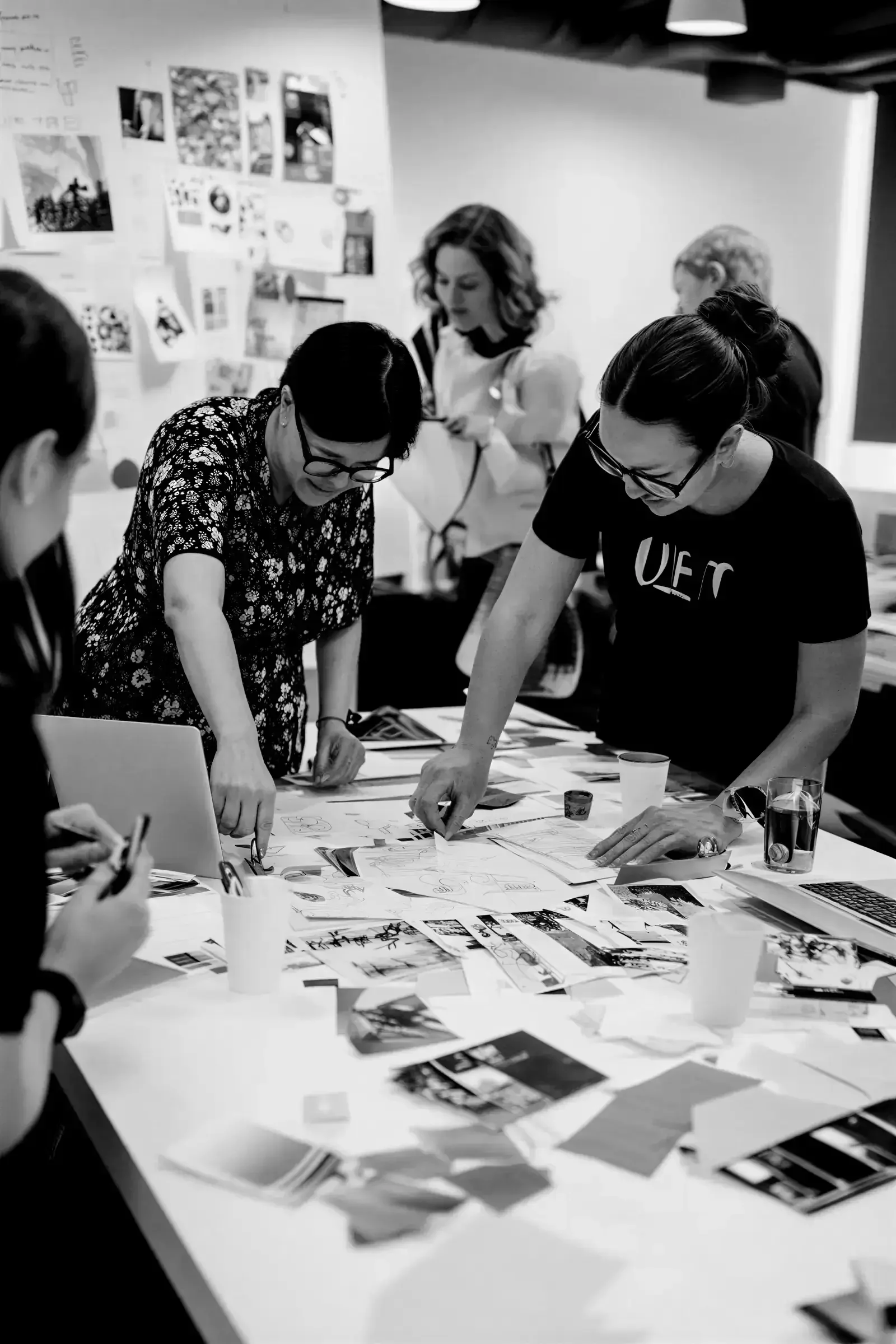 Une équipe de collaborateur en train de travailler ensemble sur une table plein de papiers et de graphiques