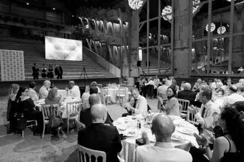 Escalier monumental à double volée dans un bâtiment institutionnel, architecture classique, lumière zénithale soulignant un cadre solennel et cérémoniel.