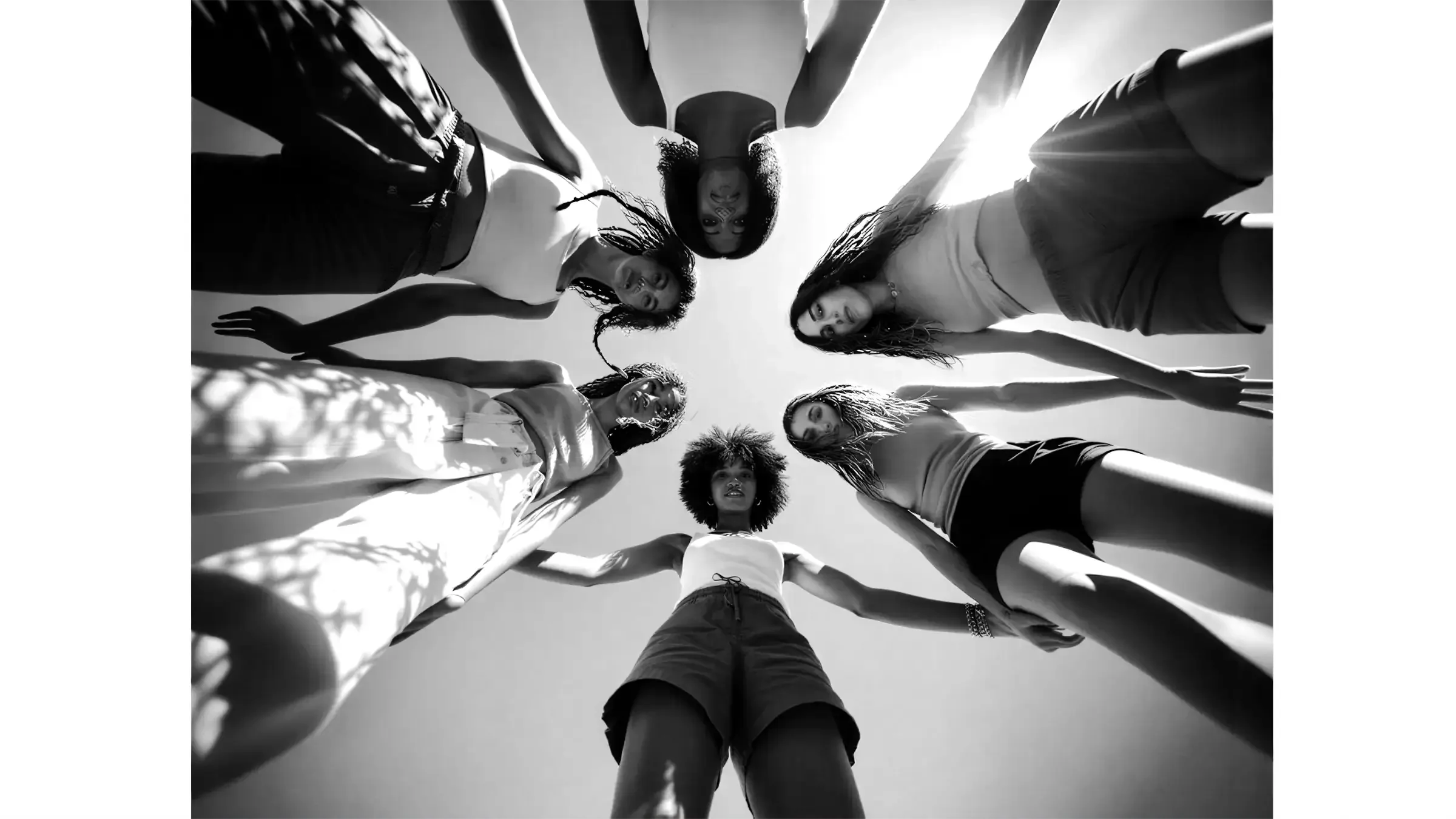 Groupe de femmes en cercle vu en contre-plongée, illustrant une action de communication interne dédiée à l’égalité professionnelle.