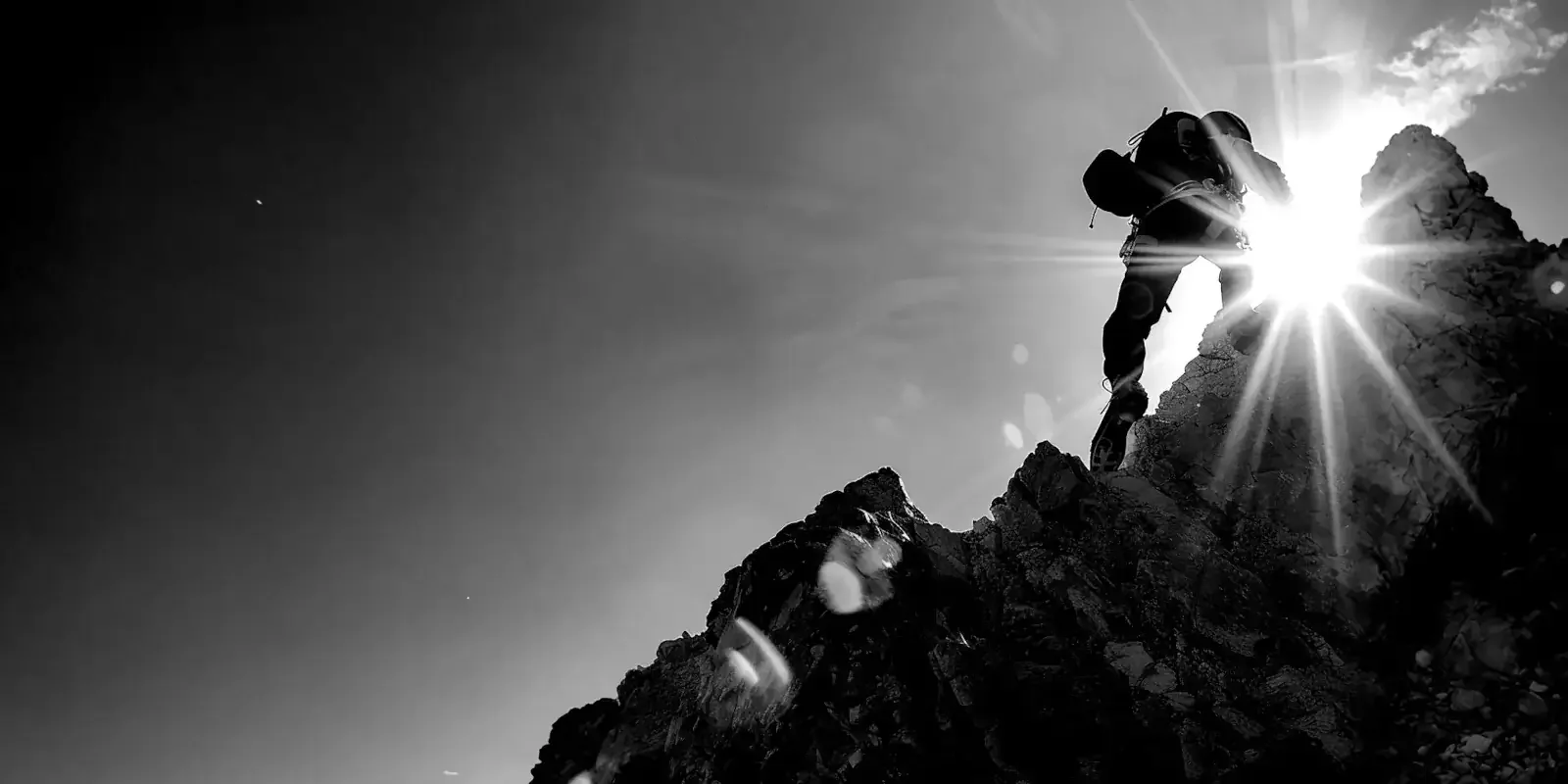 Personne gravissant un sommet au lever du soleil, illustrant la prise de hauteur, la décision lucide et la restauration d’une posture de leadership alignée.