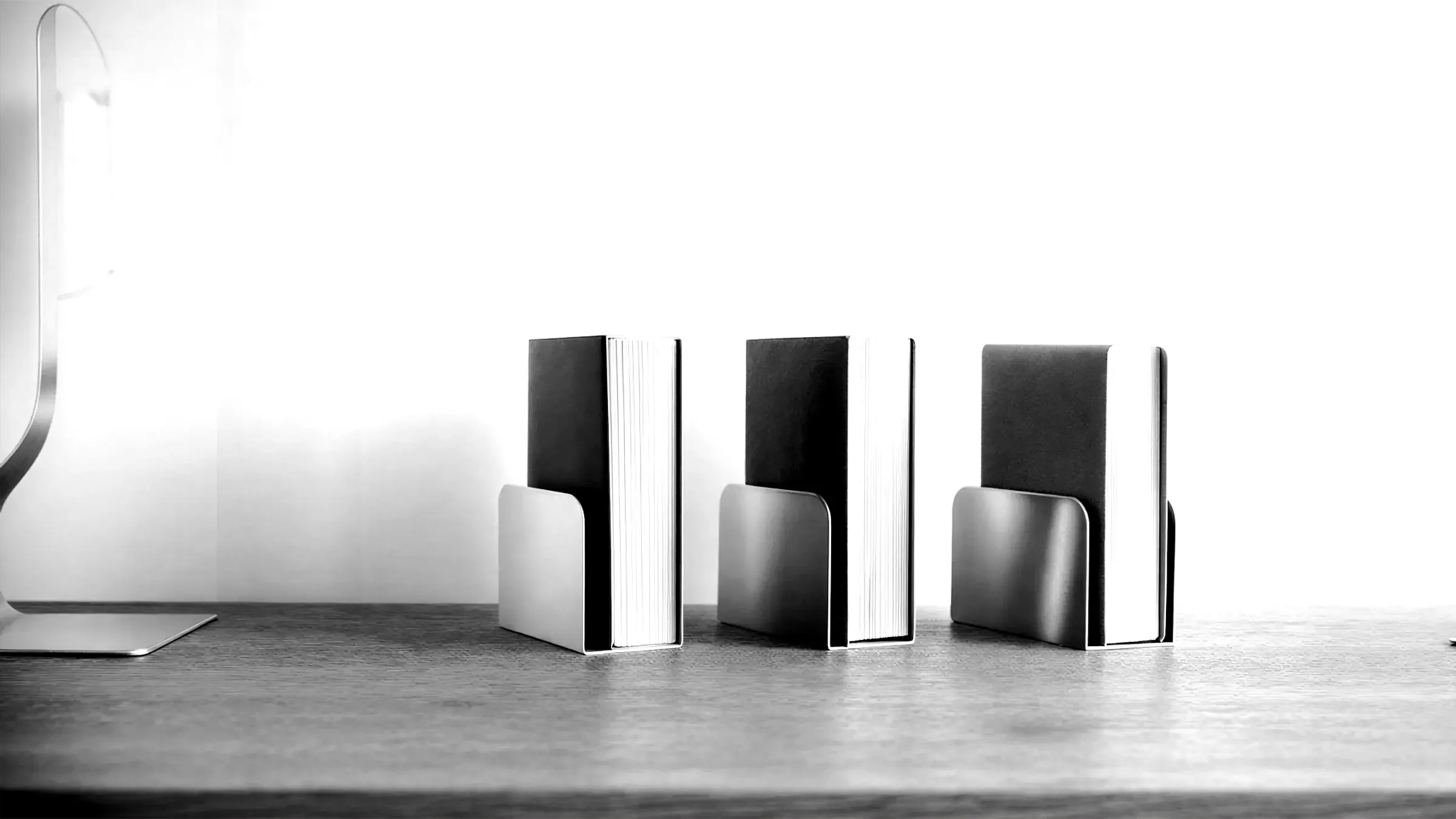 Trois livres épais rangés dans des porte-documents en métal, illustrant la formalisation, la transmission et la standardisation des savoir-faire techniques – Fulgurance, référentiels métiers et performance opérationnelle.