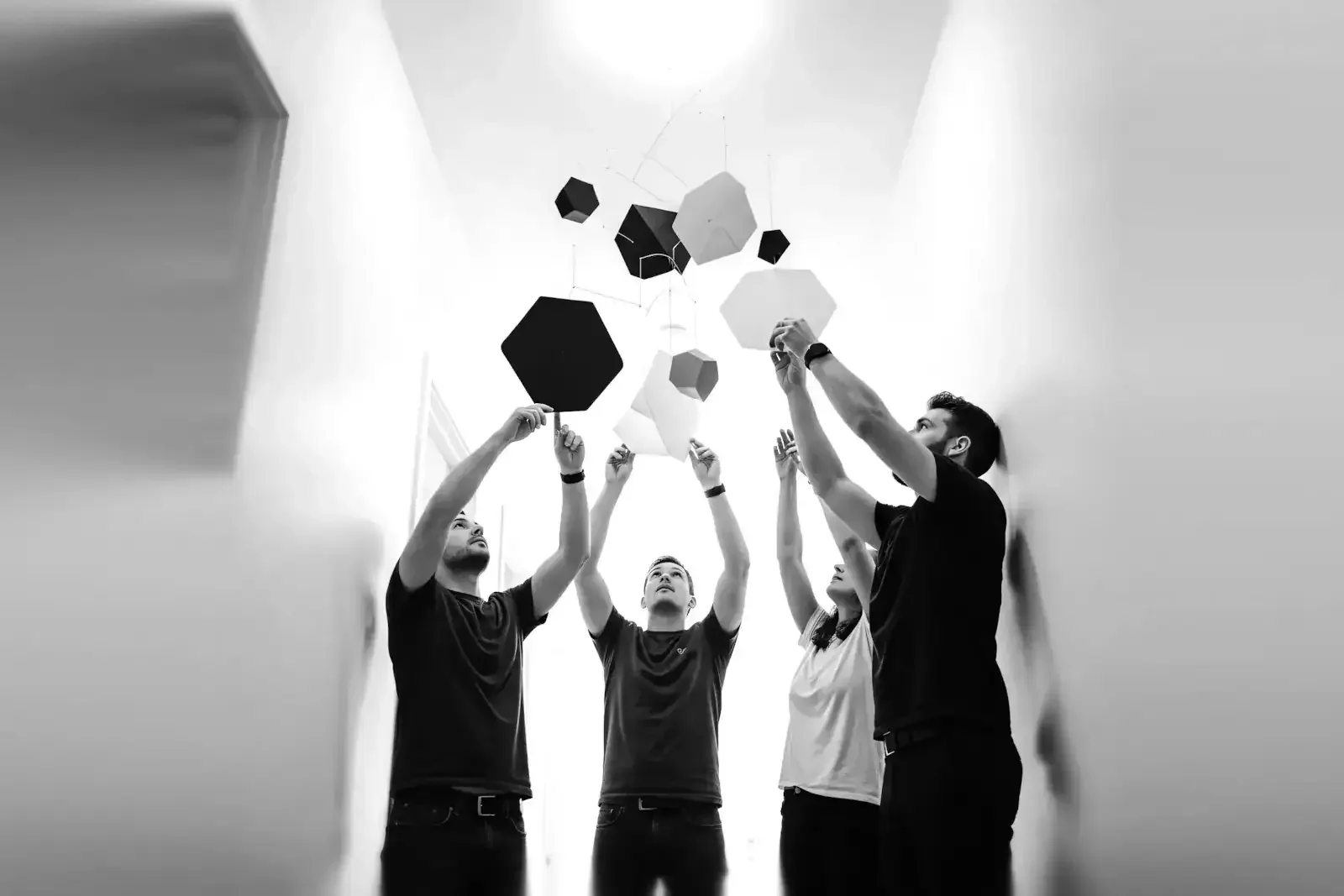 Équipe collaborant autour de formes géométriques, représentant la coopération structurée, la maturité collective et la construction d’un cadre commun solide.