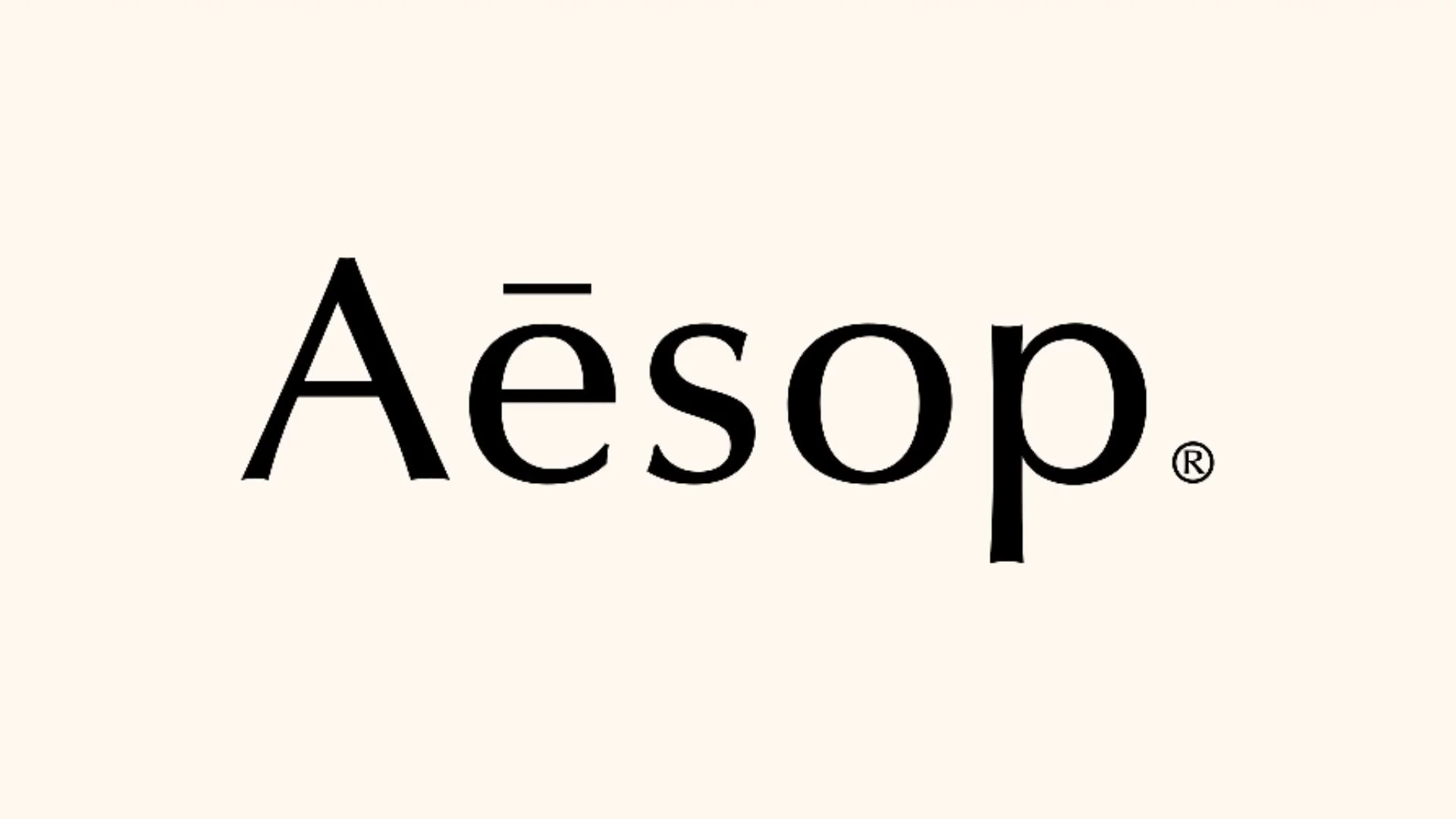 Logo d'Aesop avec le nom en lettres noires sur un fond beige