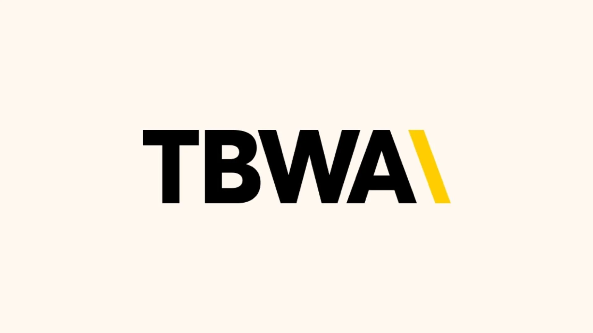 Logo avec les lettres TBWA en noir avec un accent jaune sur la dernière barre, sur un fond beige clair.