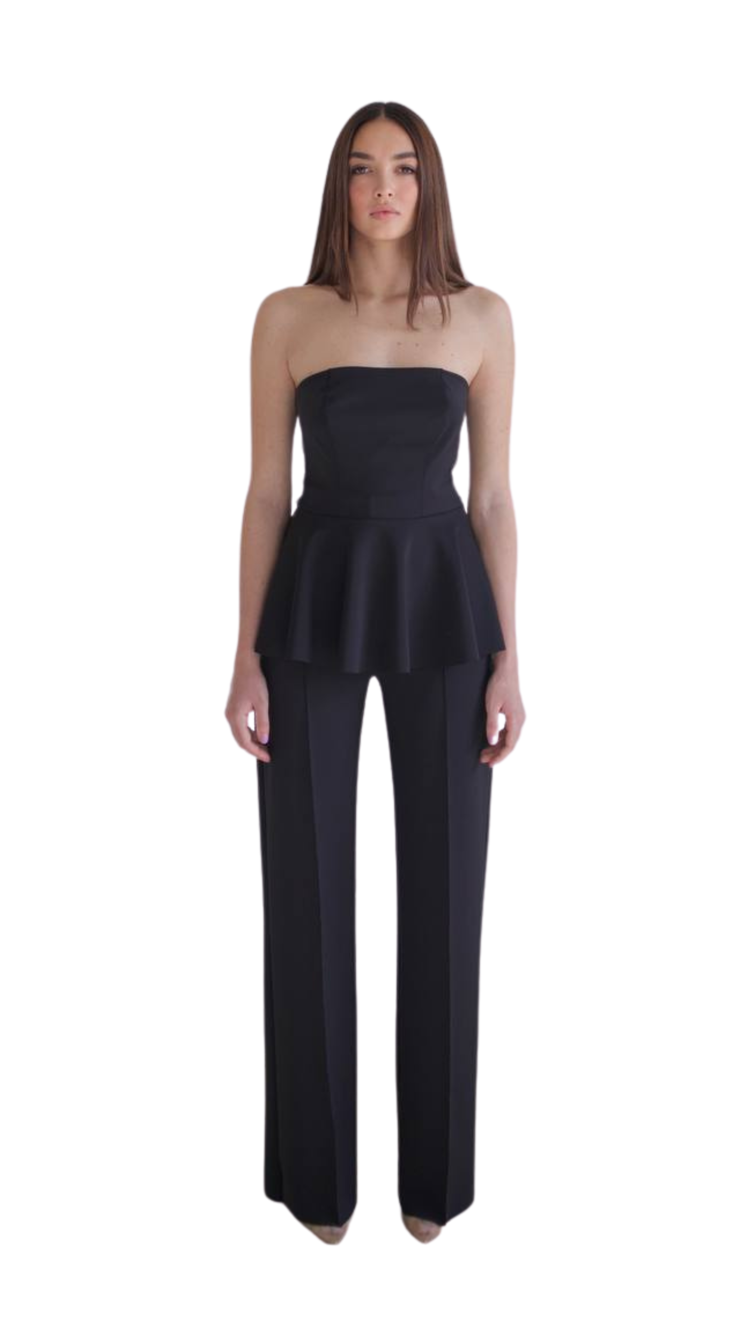 Donna giovane con abito color nero, senza spalline, e pantaloni neri lunghi, sfondo bianco.