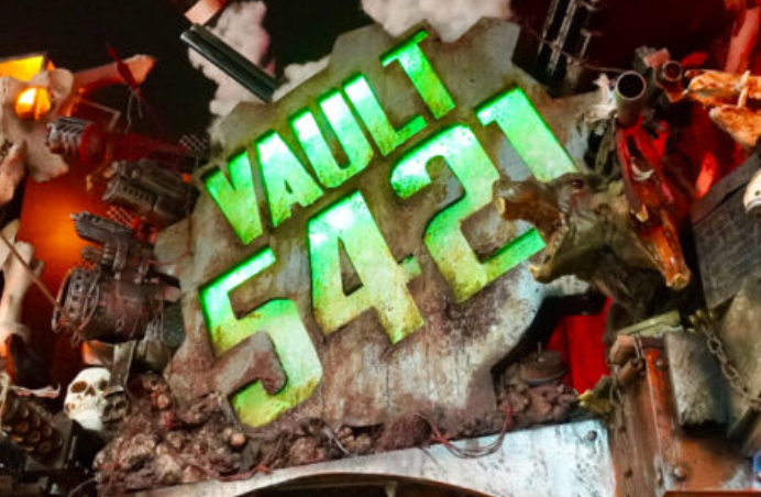 Neon sign displaying 'VAULT 5421' mounted on a textured background with elaborate sci-fi and fantasy themed decorations, including skulls, spacecraft models, and robotic figures.