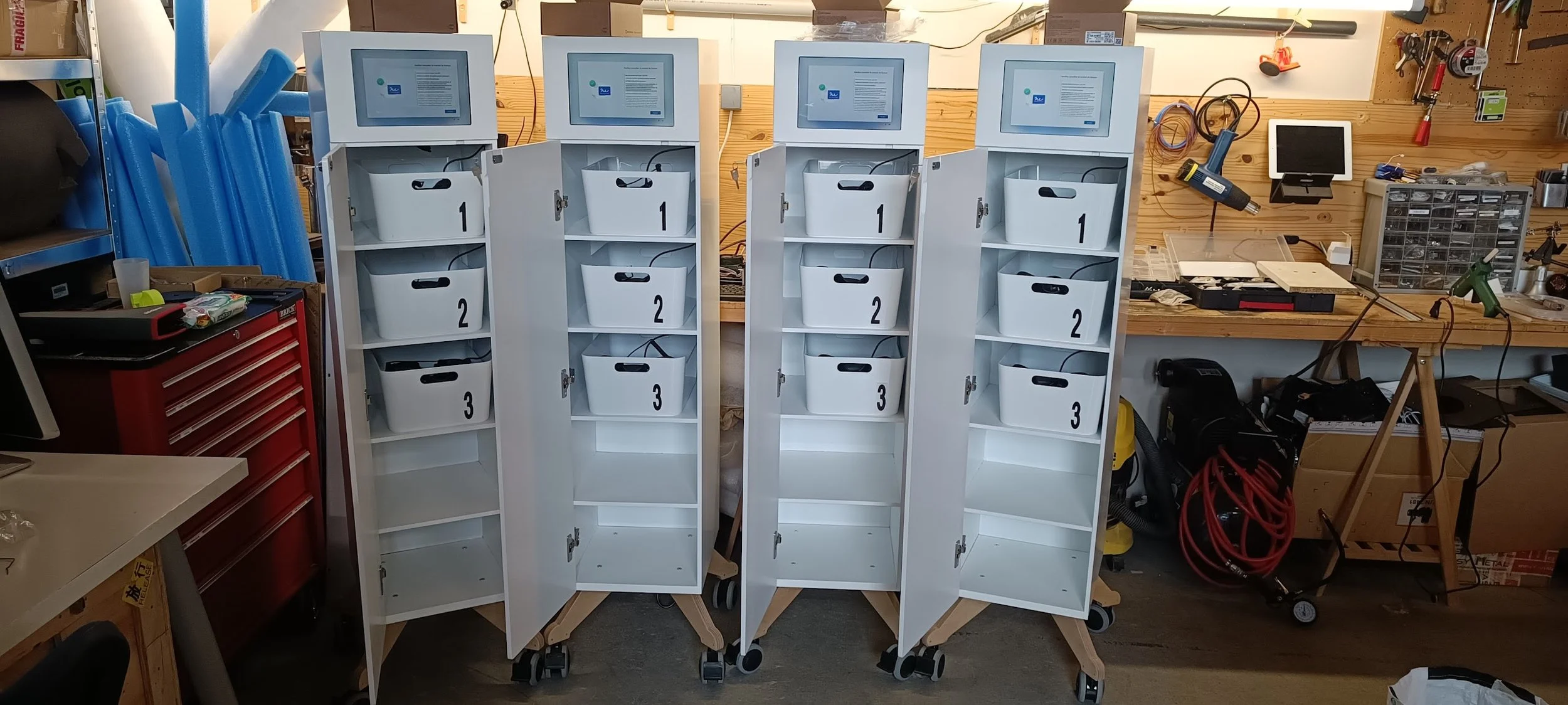 JukeboxVR Quatre armoires mobiles blanches avec des étagères remplies de casques de réalité virtuelle