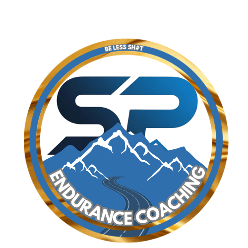 A logo for Endurance Coaching featuring a stylized mountain scene with a winding road, with text at the top reading 'BE LESS SH*T' and at the bottom 'ENDURANCE COACHING'.