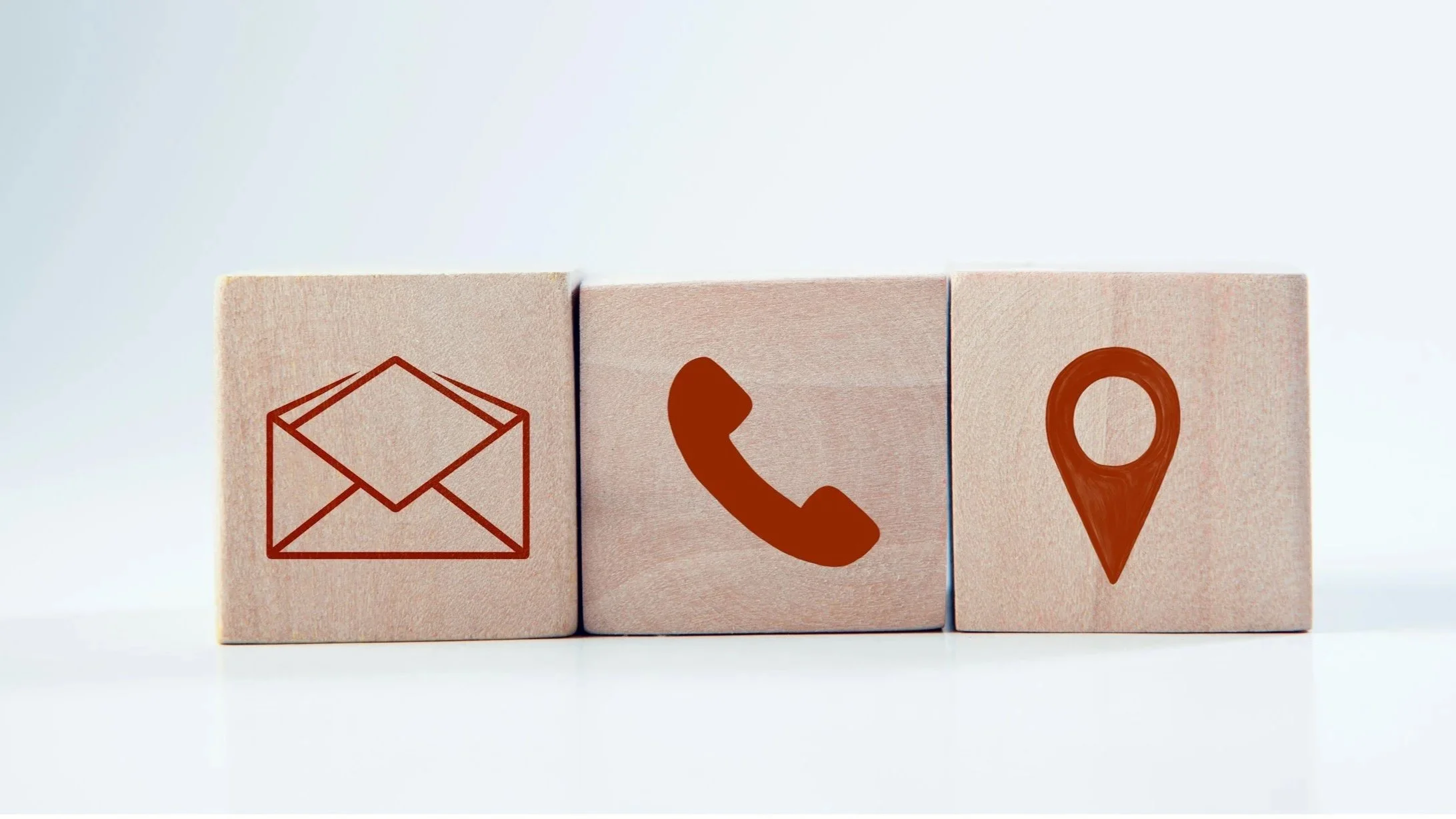 Three beige blocks with red symbols of an envelope, a phone, and a location marker.