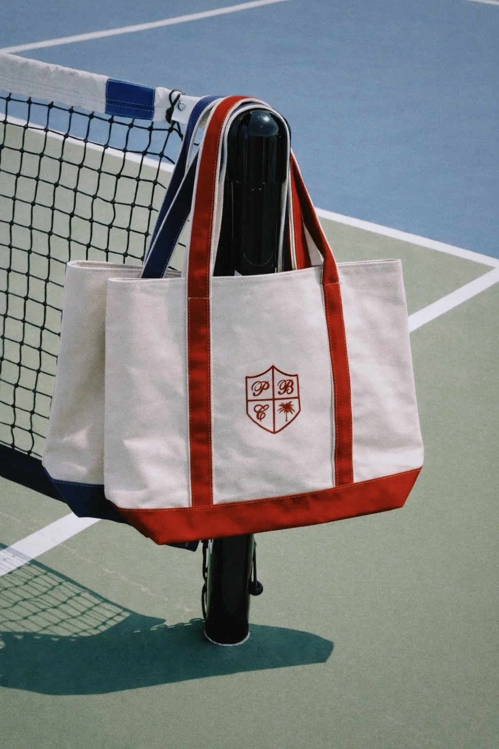 Canvas bag with red and blue straps and PBC crest logo embroidered in red stitching