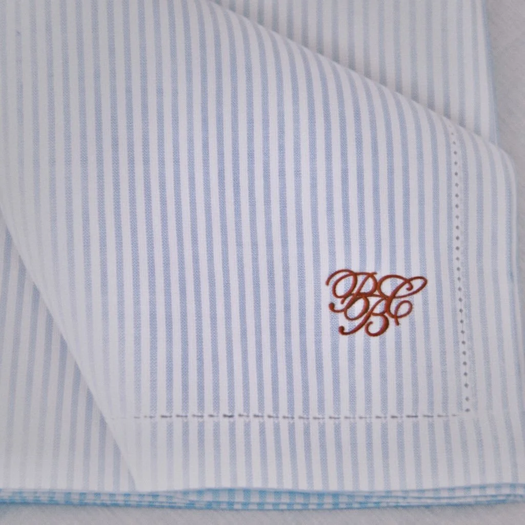 White and blue striped linen napkin with PBC embroidered in red stitching