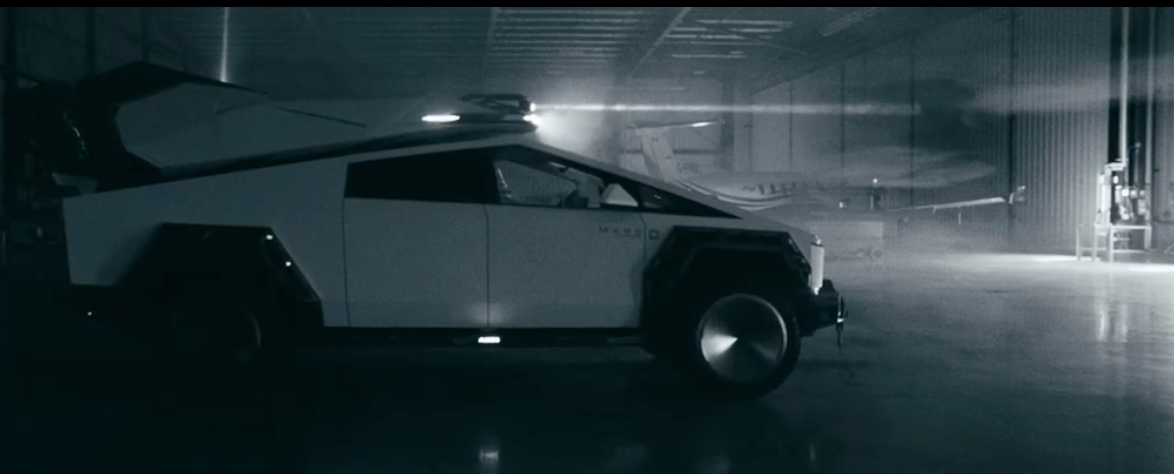 A futuristic, sci-fi space vehicle parked inside a large, dimly-lit hangar or workshop.