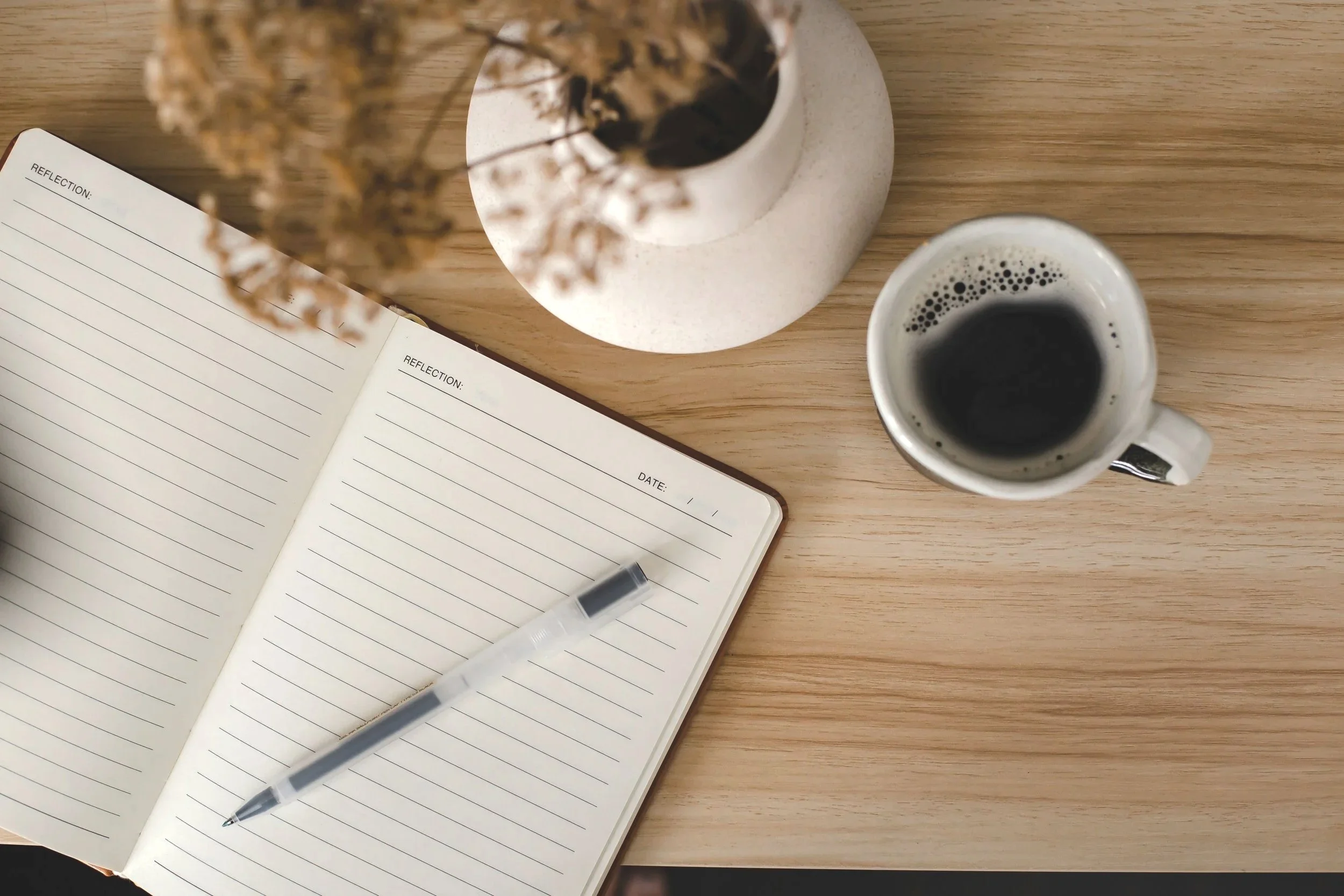 "A notebook and a warm mug of coffee on a table, representing a peaceful space for online Christian therapy for women in Florida.