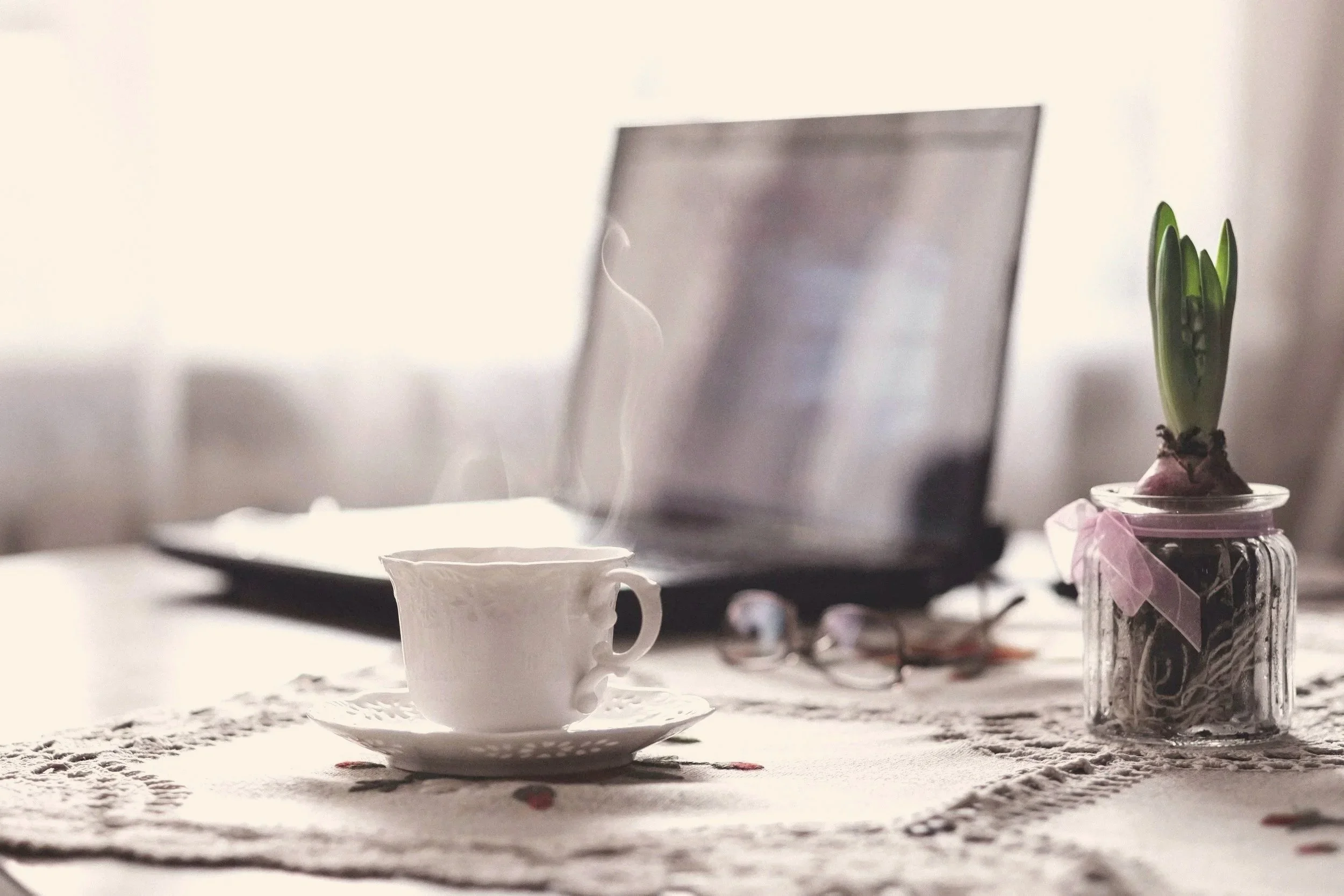 Desk with laptop and a mug of coffee ready for a telehealth therapy session