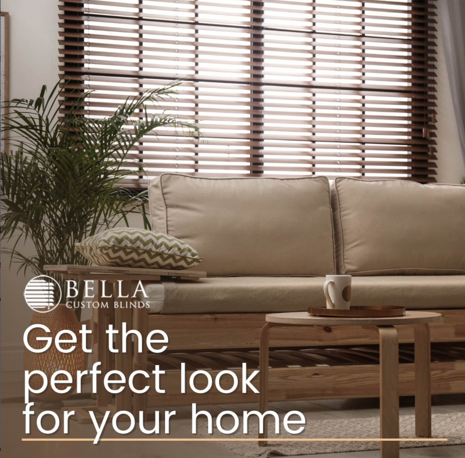 Living room with beige sofa, wooden blinds, potted plant, side table with decorative pillow, coffee table with mug, and curtains, promoting custom blinds for home decor.