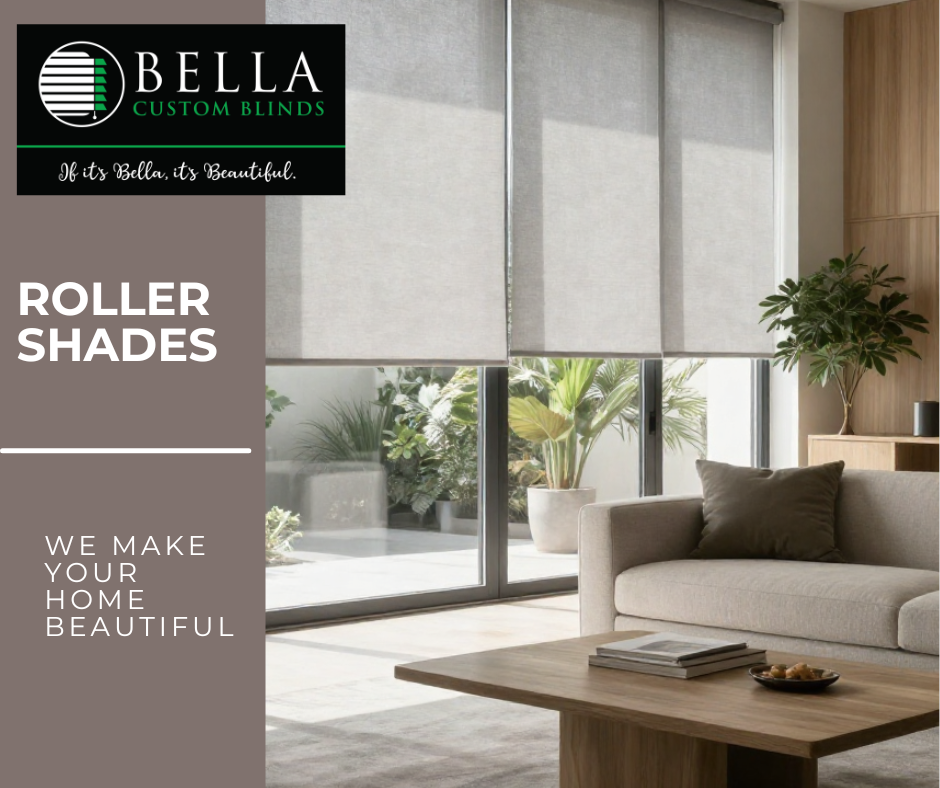 Living room with large windows covered by roller shades, a beige sofa with a brown pillow, a wooden coffee table with books and a bowl, a potted plant, and a wooden cabinet.