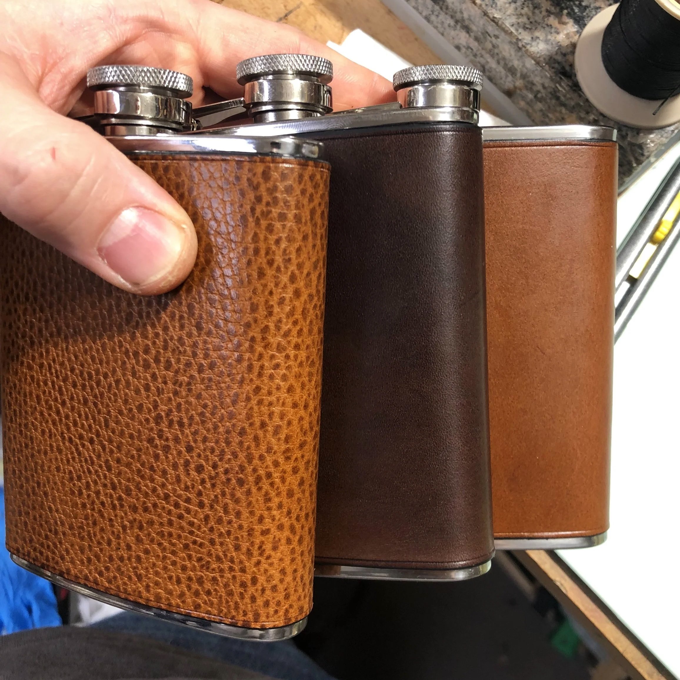 Drei Flachmänner, mit verschiedenen Ledern umkleidet