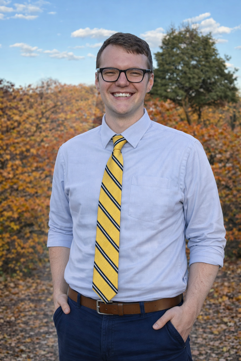 A smiling person sitting while holding a pumpkin at a farm.. 