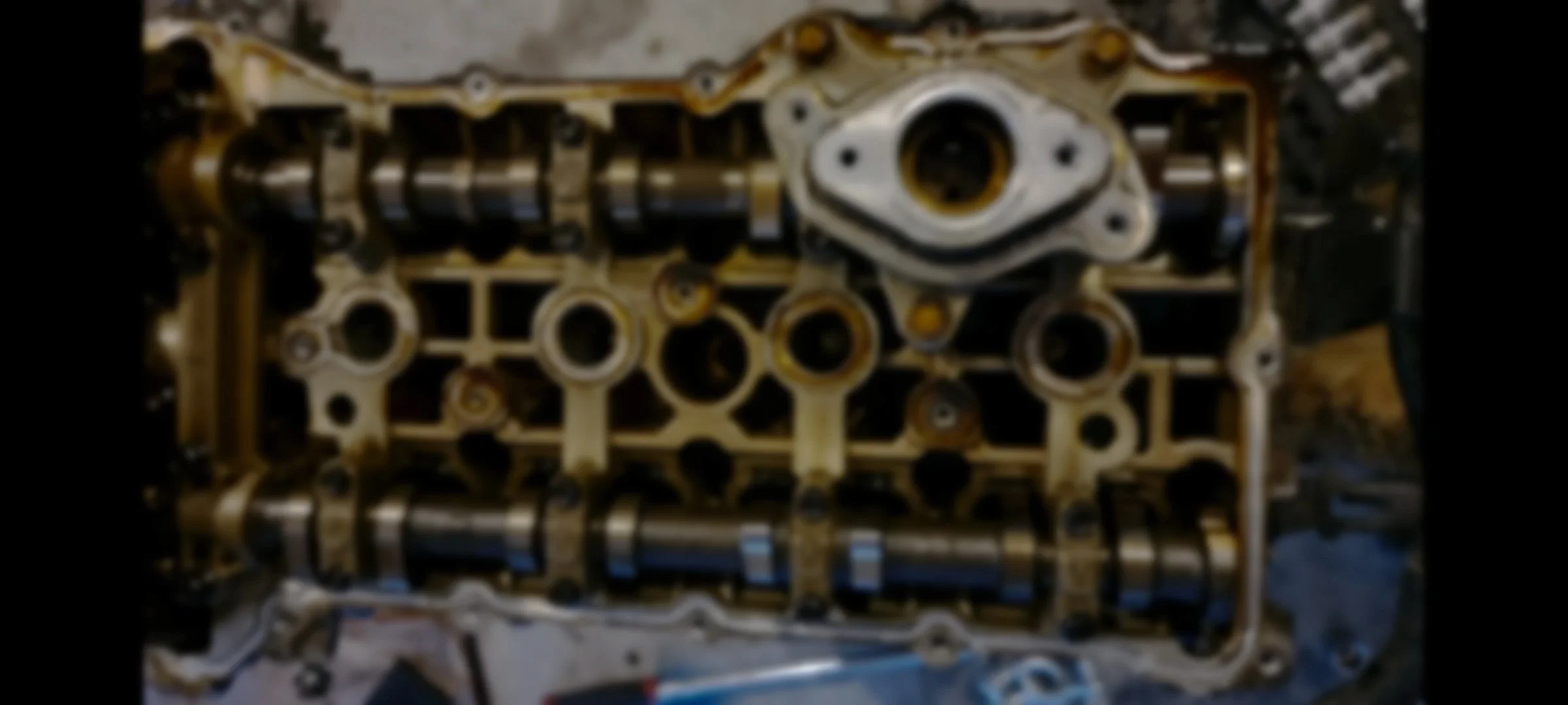 Blurry engine cylinder head with visible camshafts and valves.