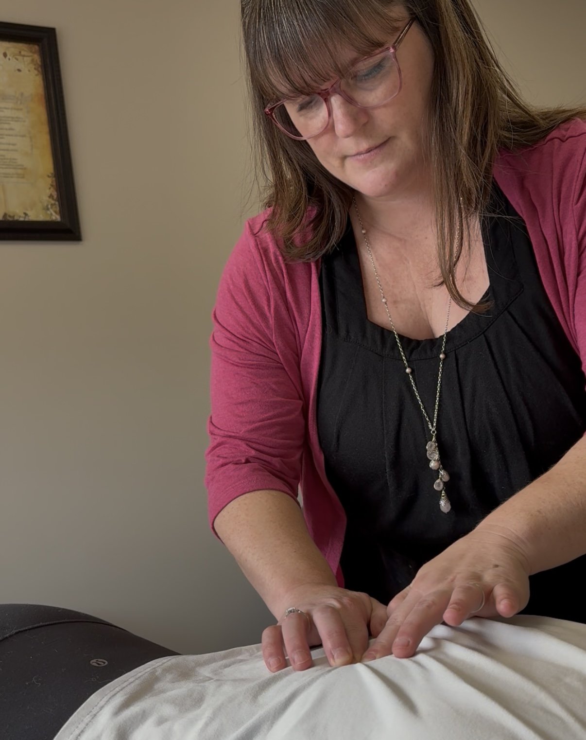 A woman performing Bowen Therapy on a person's back.