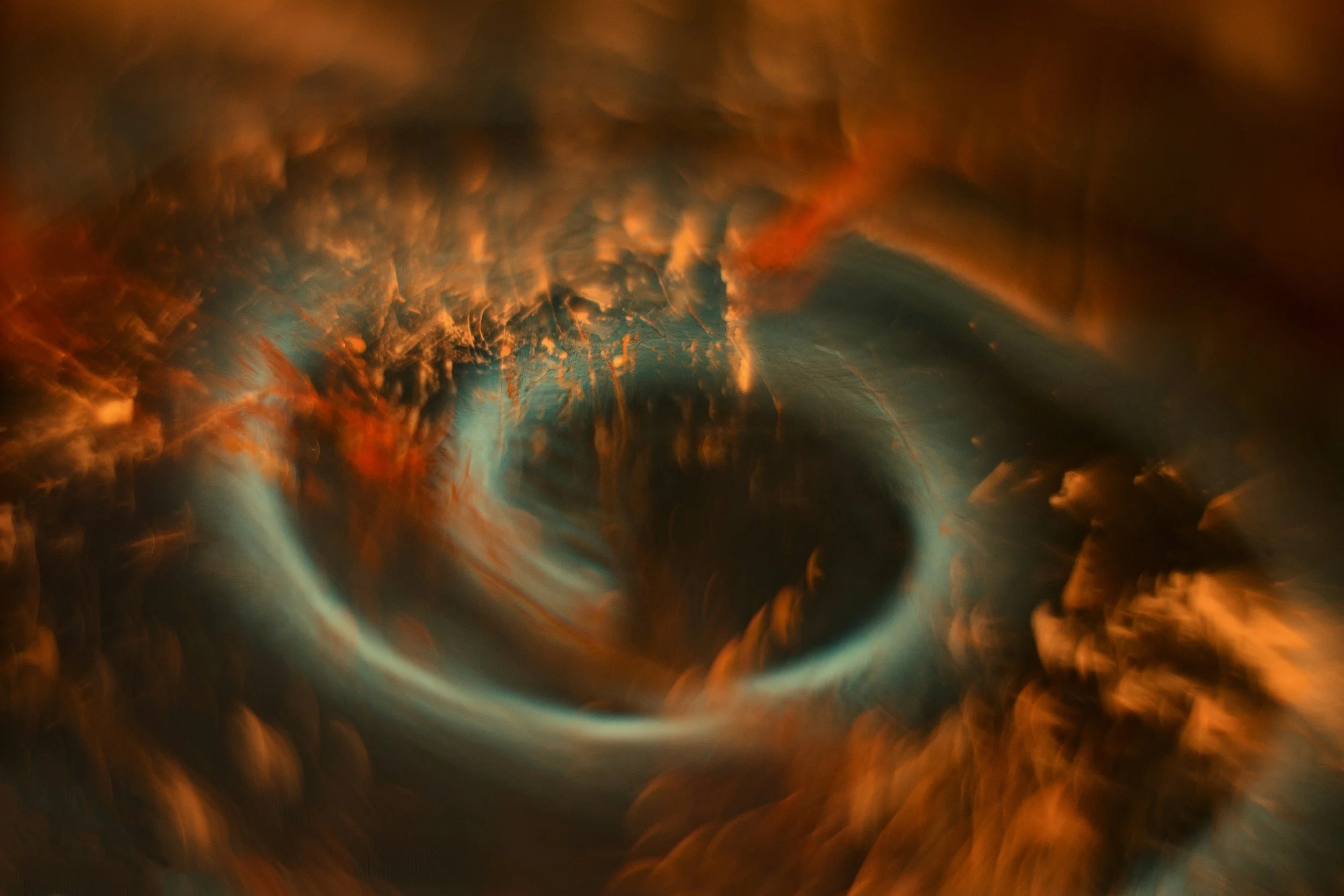 A swirling, abstract pattern of fiery orange, red, and teal colors resembling a cosmic or nebula-like scene.