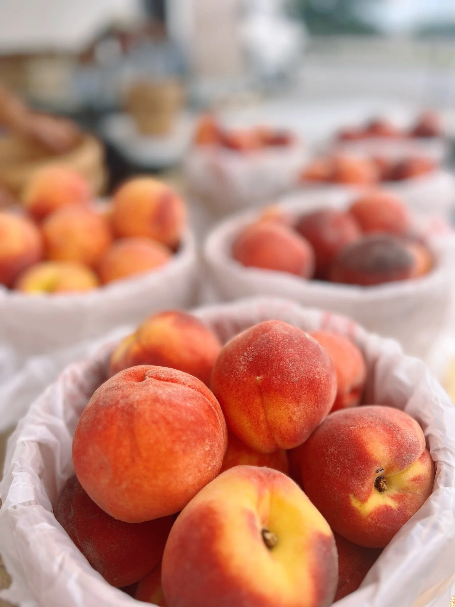 Close-up of fresh peaches in a basket at a market