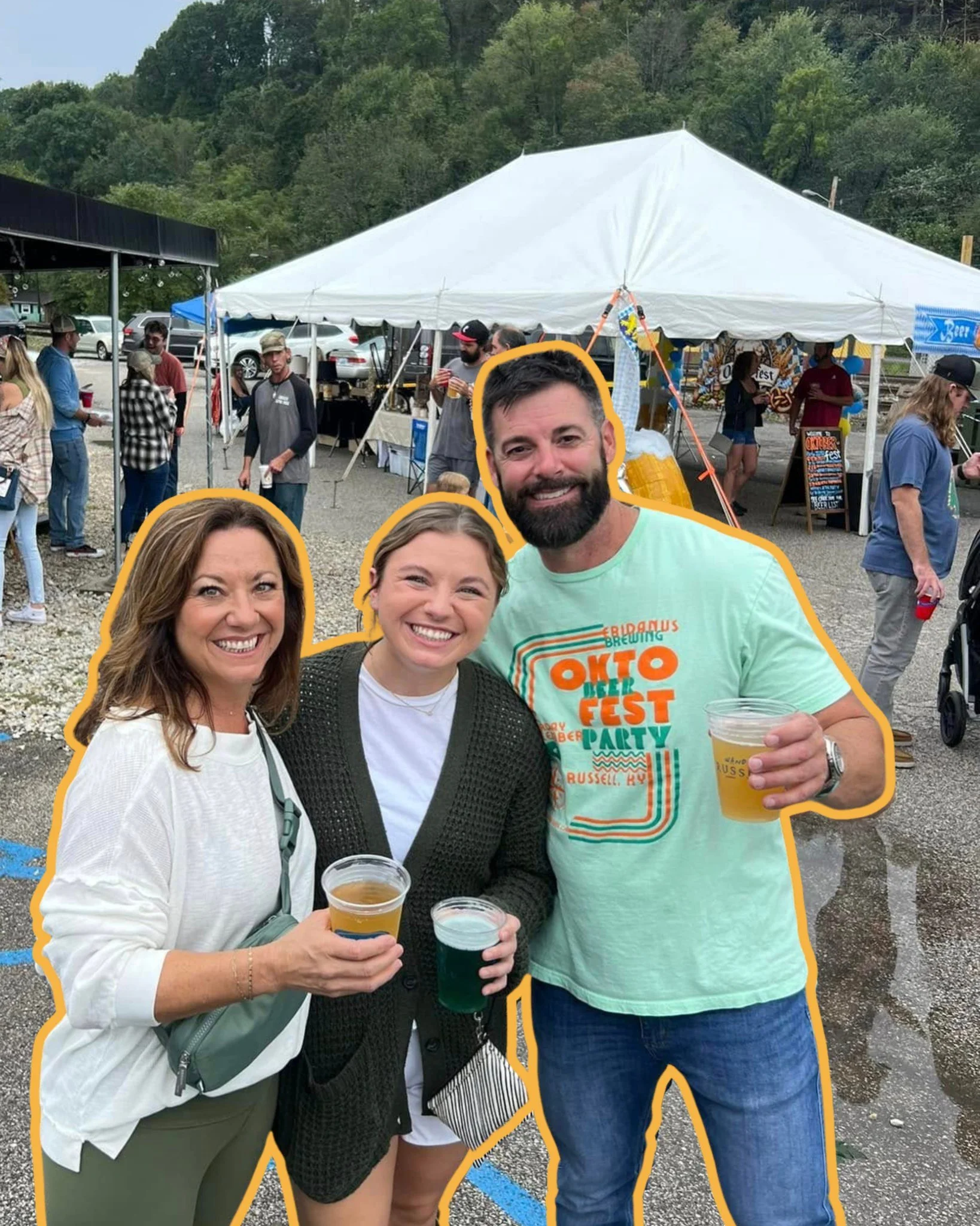 People enjoying a festival outdoors with a tent in the background, holding drinks, smiling for the camera.