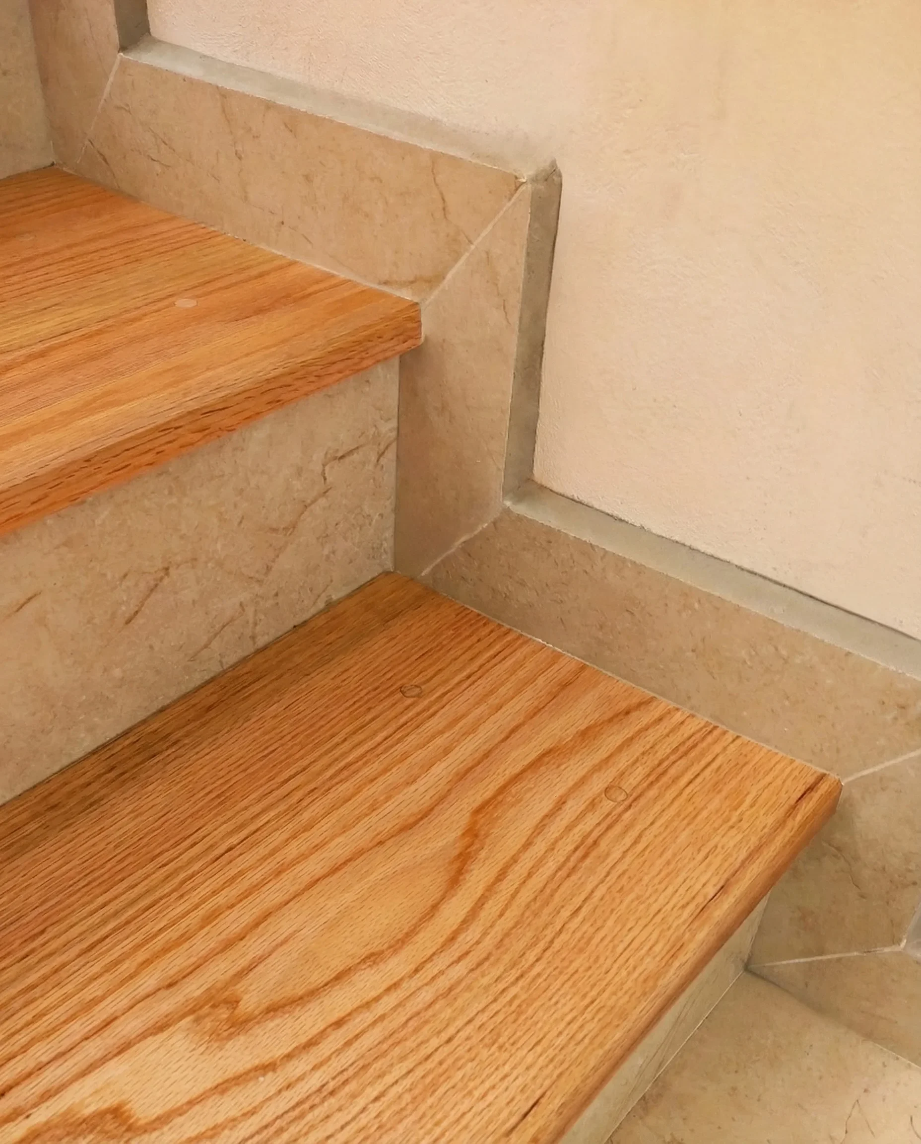 Escalones de madera de encino sólido con ensamble milimétrico sobre base de concreto, detalle técnico de carpintería Estudio Madera.