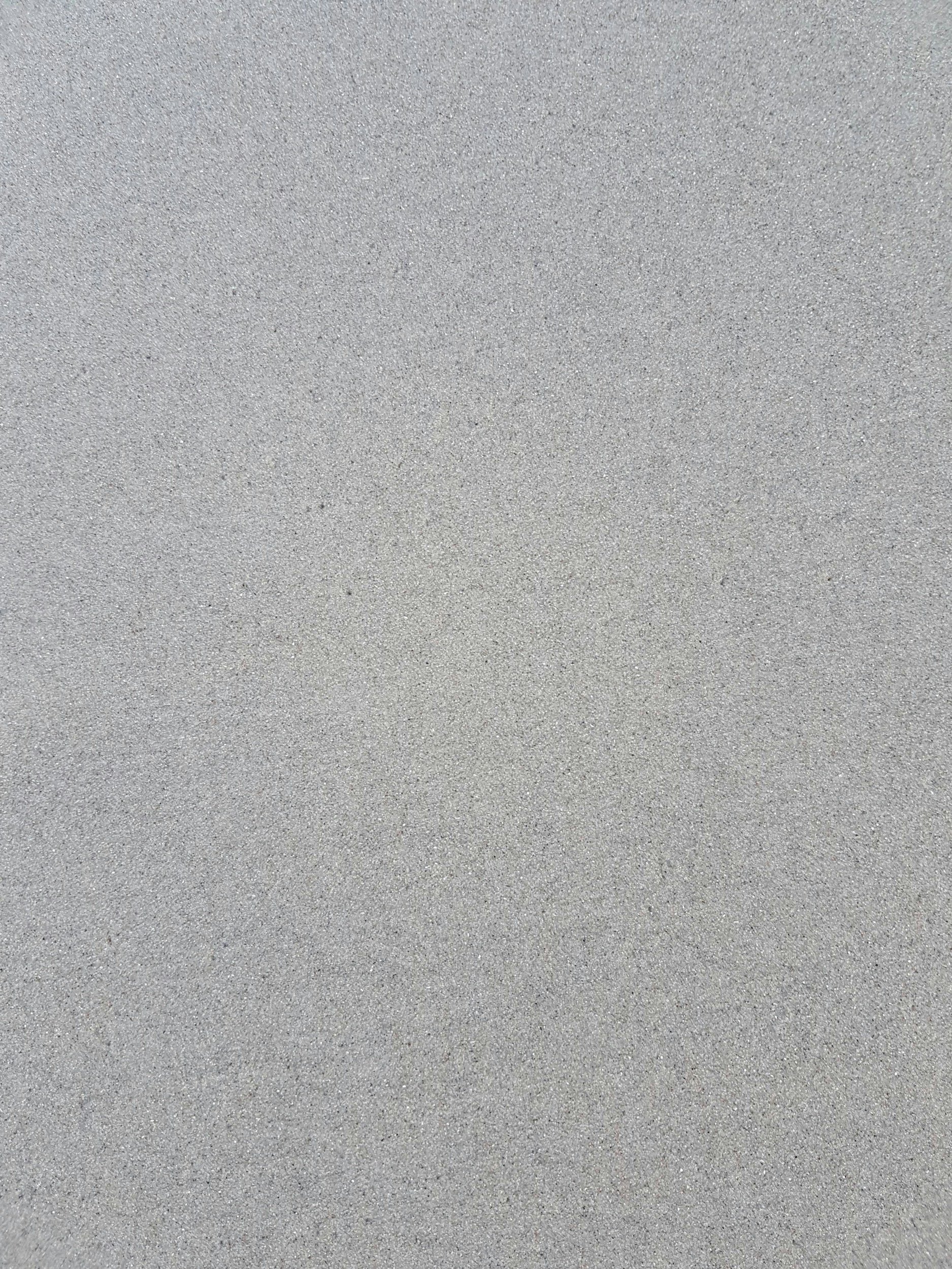 Detalle táctil y mineral de una cubierta de superficie sólida en color gris neutro, de alta resistencia mecánica y térmica para encimeras contemporáneas.